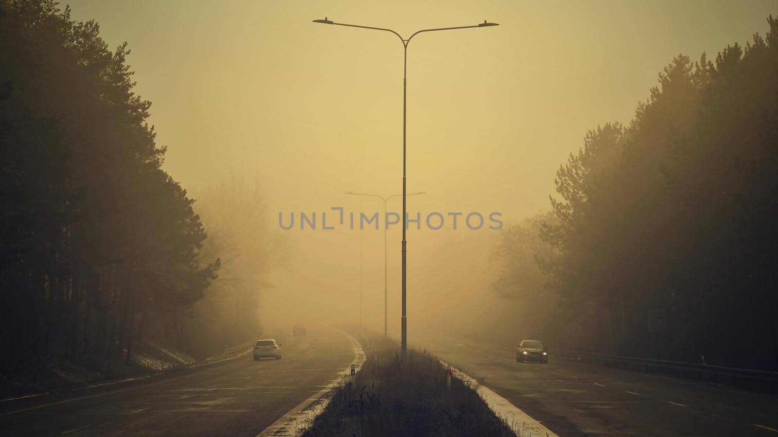 Cars in the fog. Bad winter weather and dangerous automobile traffic on the road. Vehicles in fog.