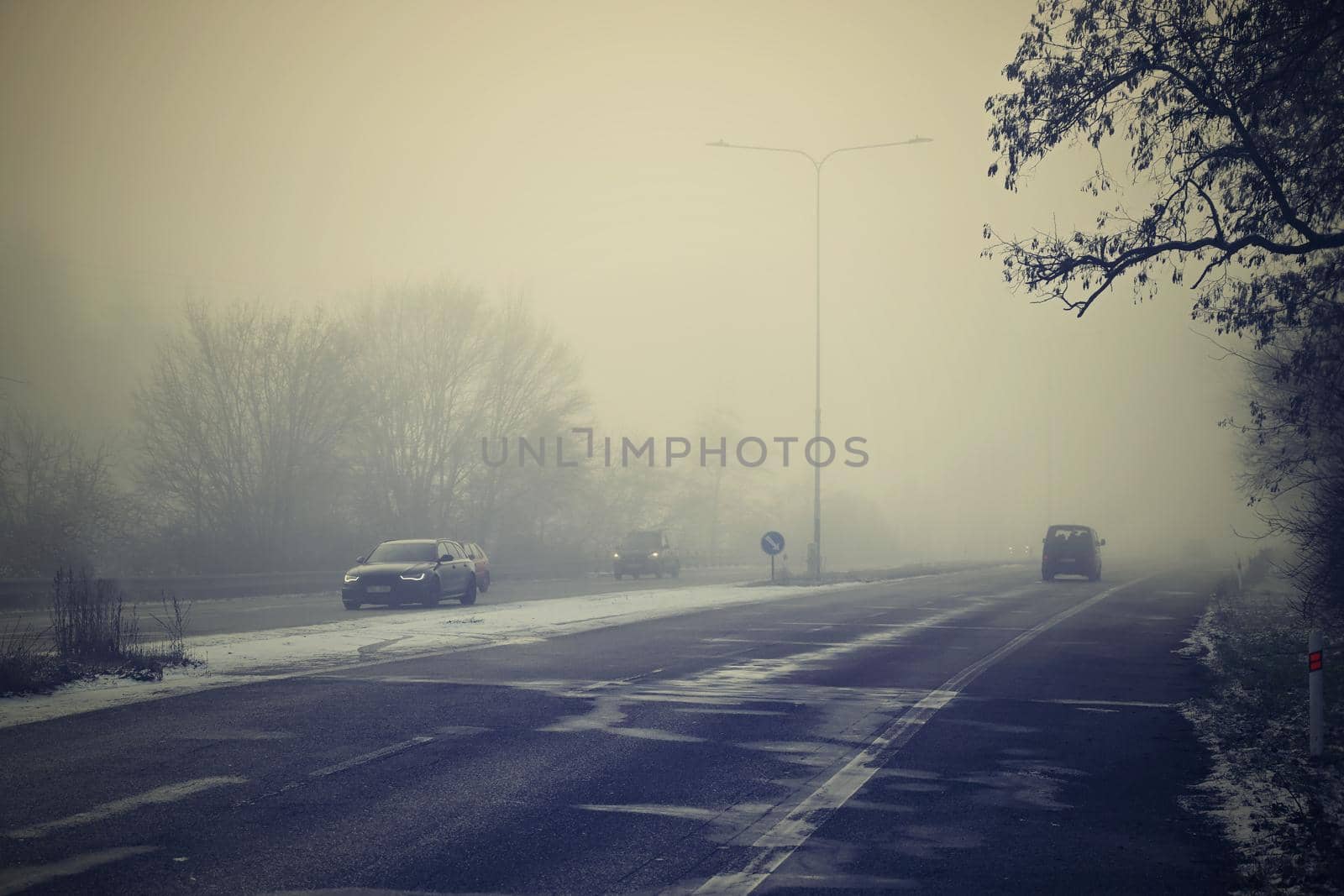 Cars in the fog. Bad winter weather and dangerous automobile traffic on the road. Vehicles in fog.