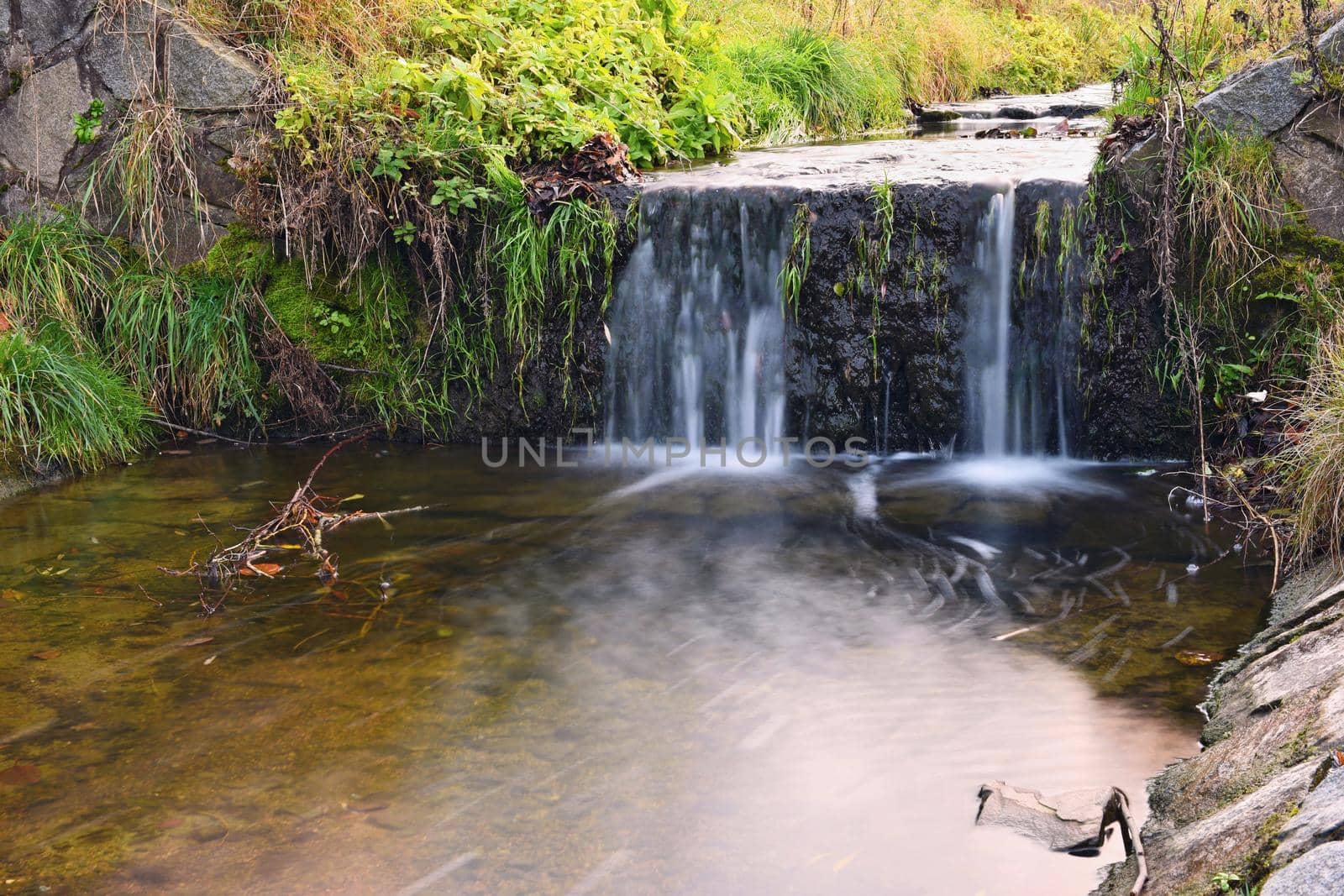 A beautiful clean brook in the countryside with a sink and running water.