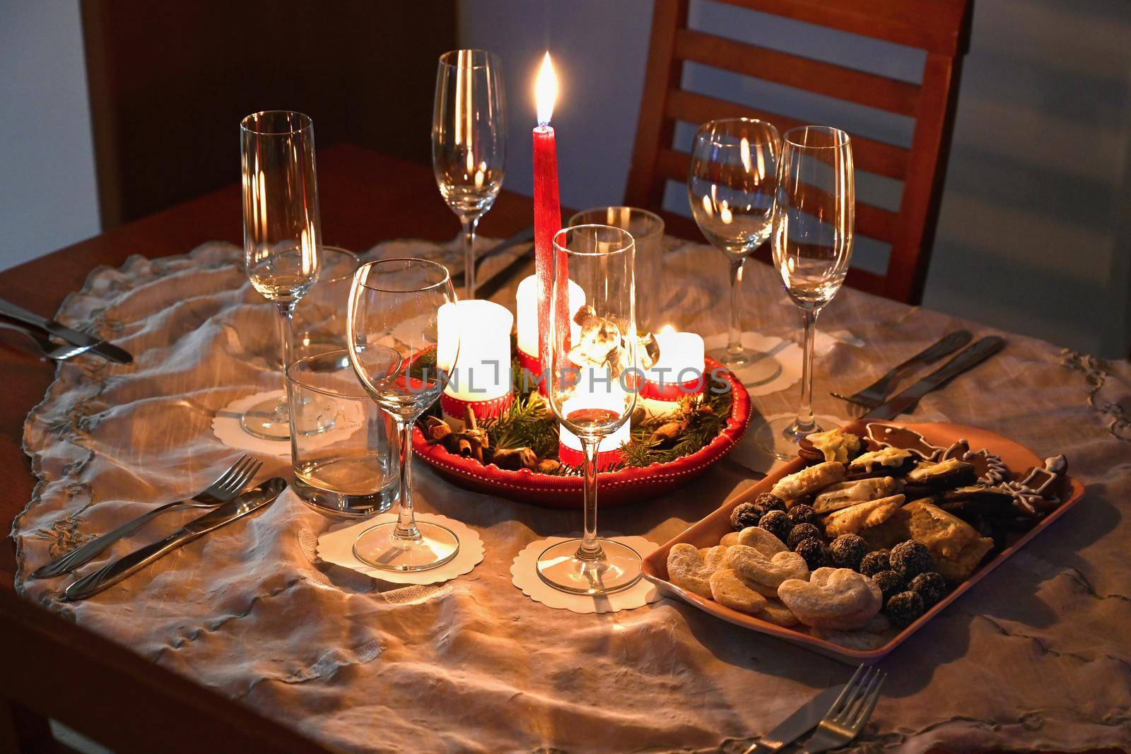 Beautifully set table for Christmas holidays. Candies, candles and Christmas decorations - decorated home on Christmas Eve.