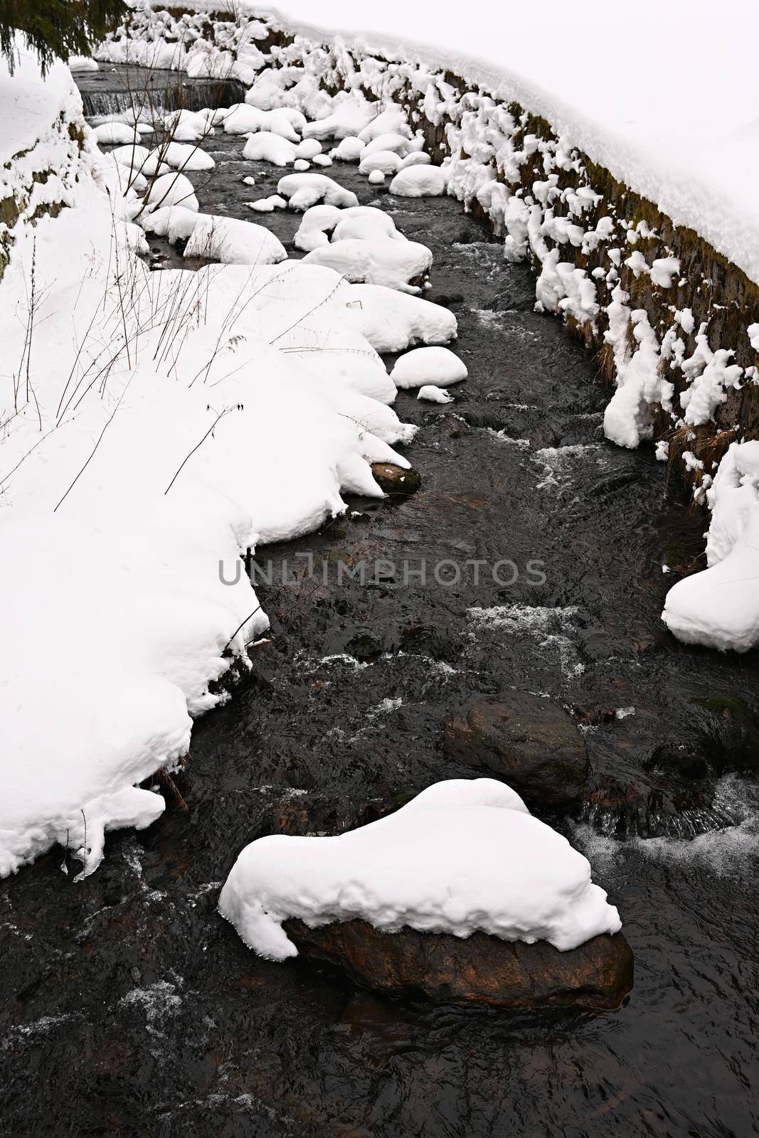 Winter stream with stones and snow. A beautiful winter concept for winter and frost. by Montypeter