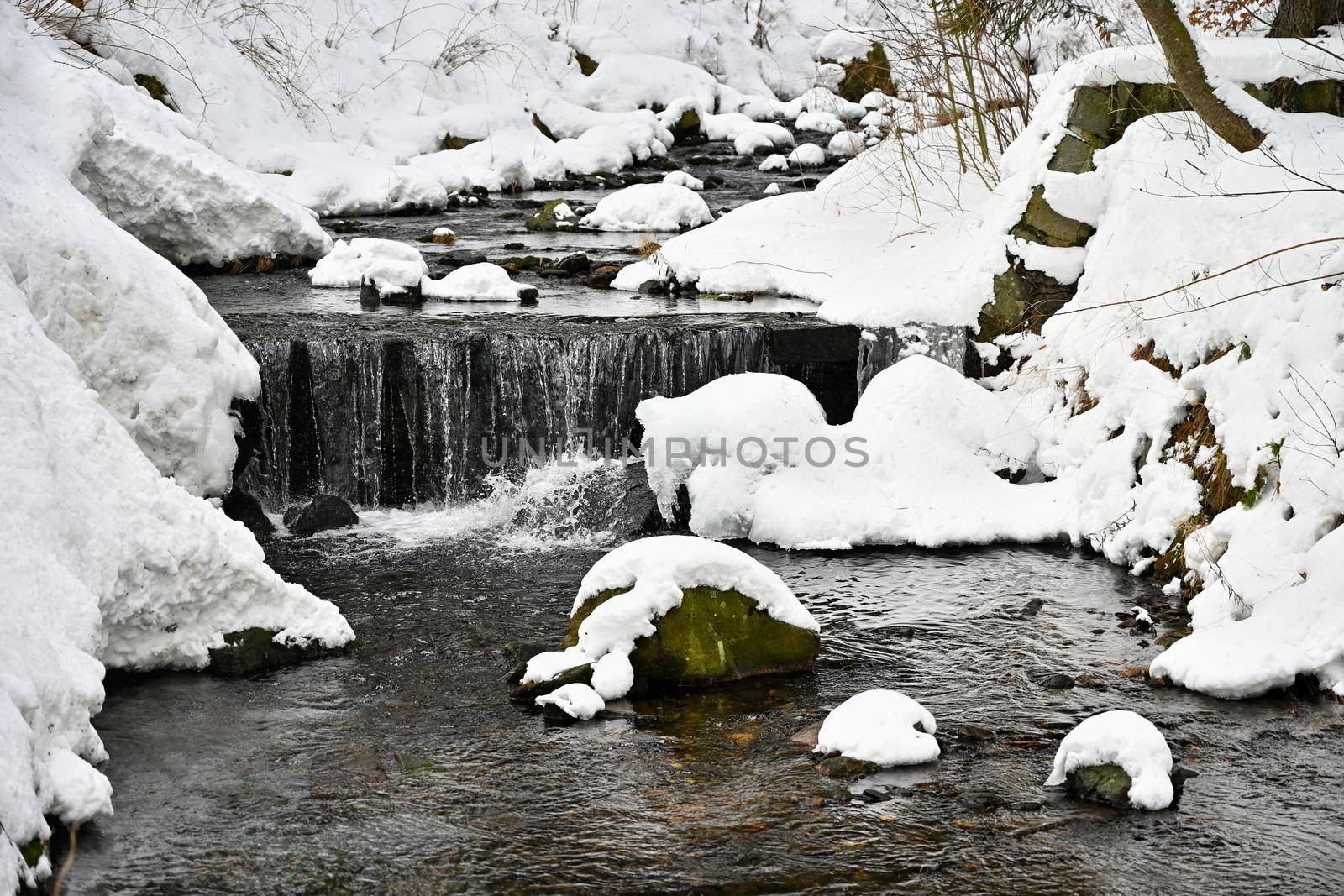 Winter stream with stones and snow. A beautiful winter concept for winter and frost.