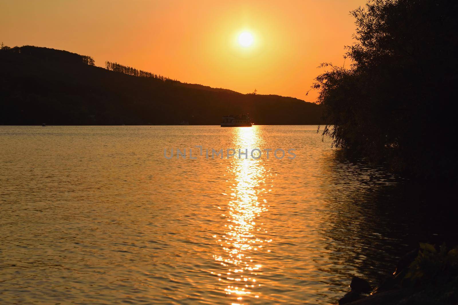 Brněnská přehrada, the city of Brno-Europe. Beautiful sunset by water with a boat.