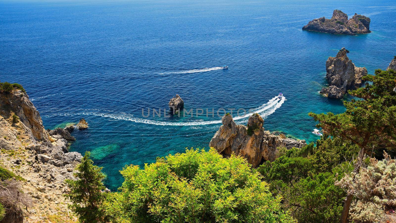 Beautiful beach and boats. Clean sea with a bay. Concept for travel, vacation and tourism. Great place for summer holidays and swimming. Paleokastritsa, Corfu island, Greece.