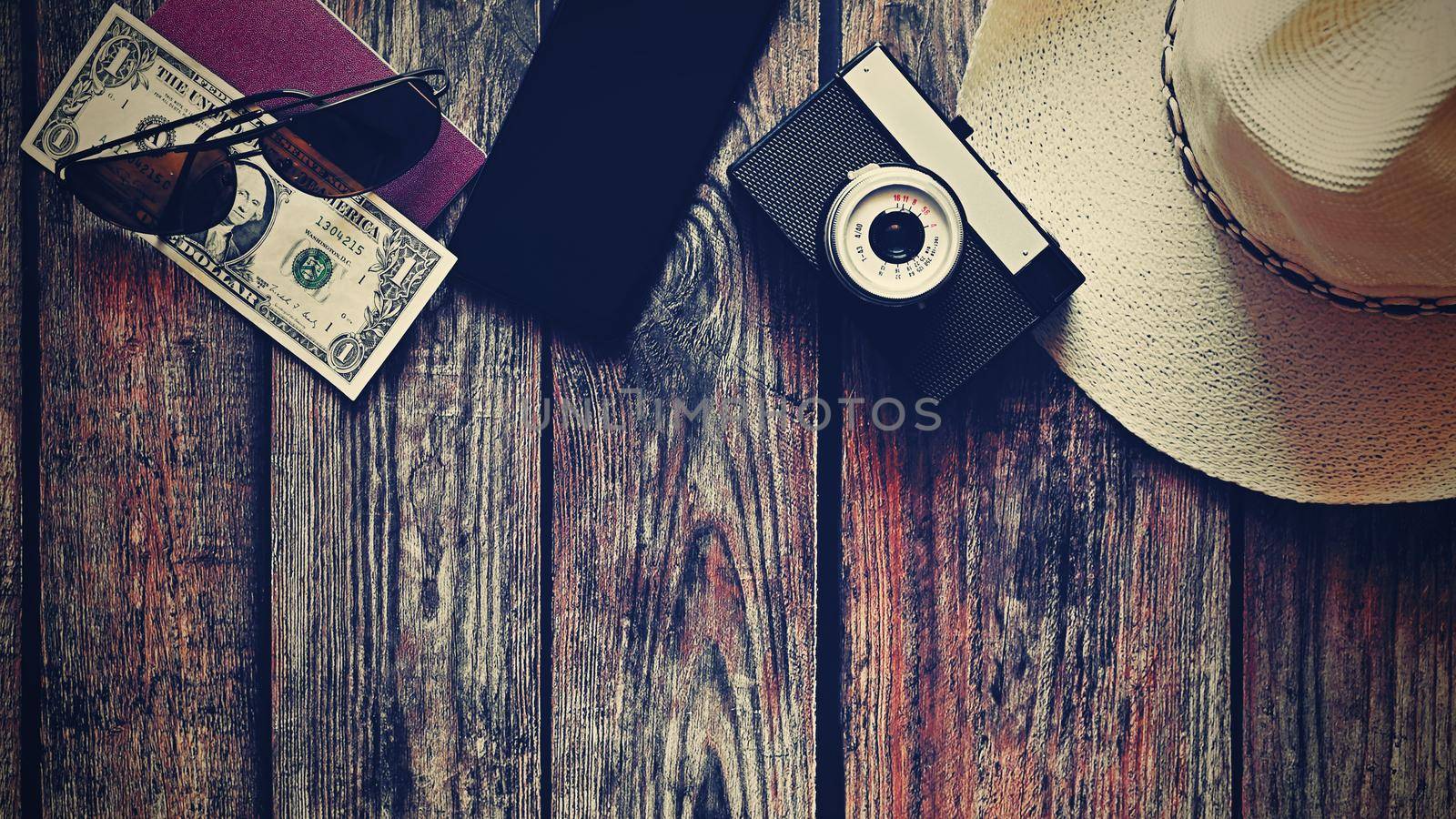 Items for summer vacation: a camera, passport,smartphone, money, hat, sunglasses. Wooden background, top view with Copy space. Beautiful summer concept for travel and summer vacation. by Montypeter