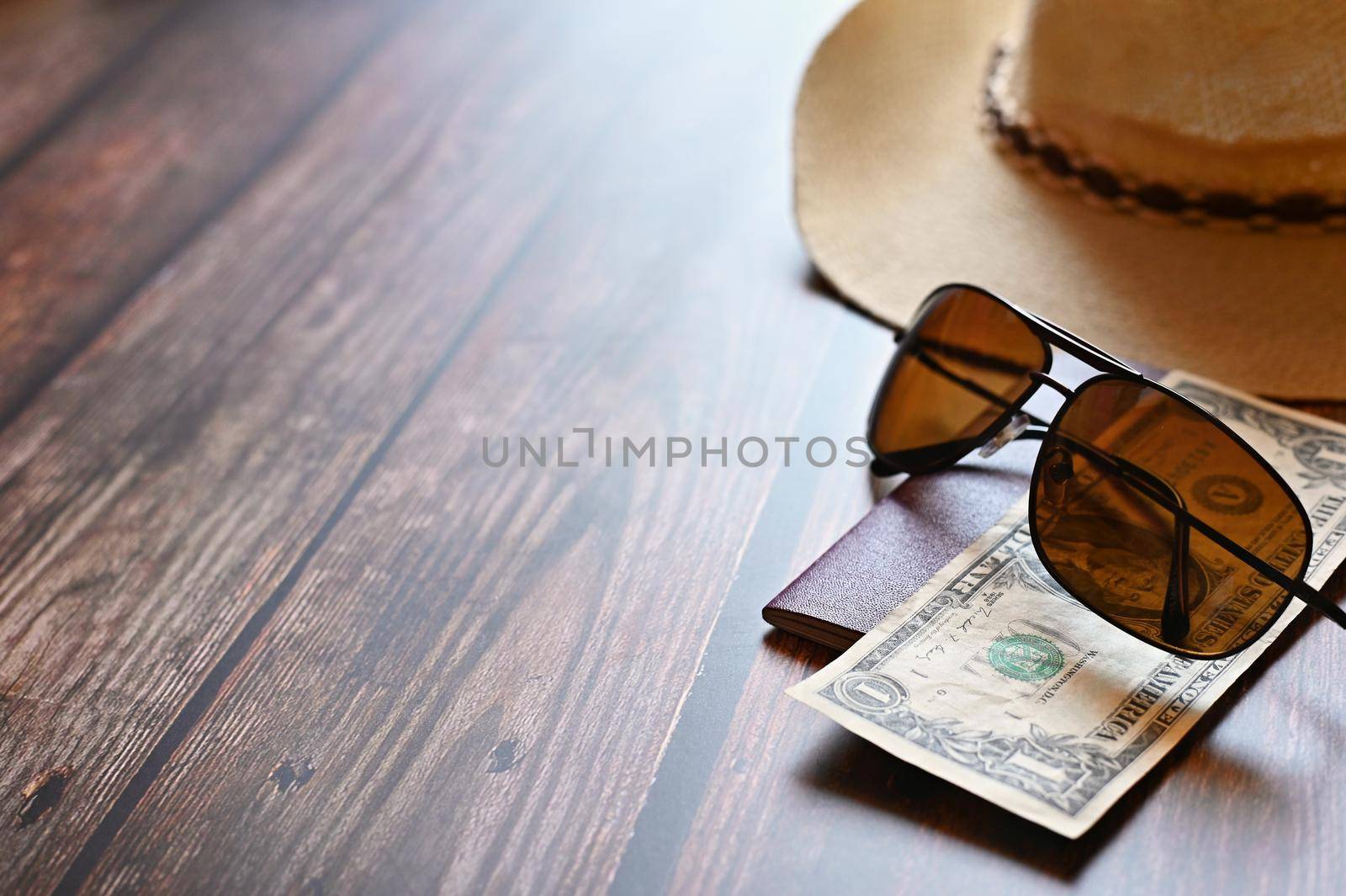 Items for summer vacation: a camera, passport,smartphone, money, hat, sunglasses. Wooden background, top view with Copy space. Beautiful summer concept for travel and summer vacation.