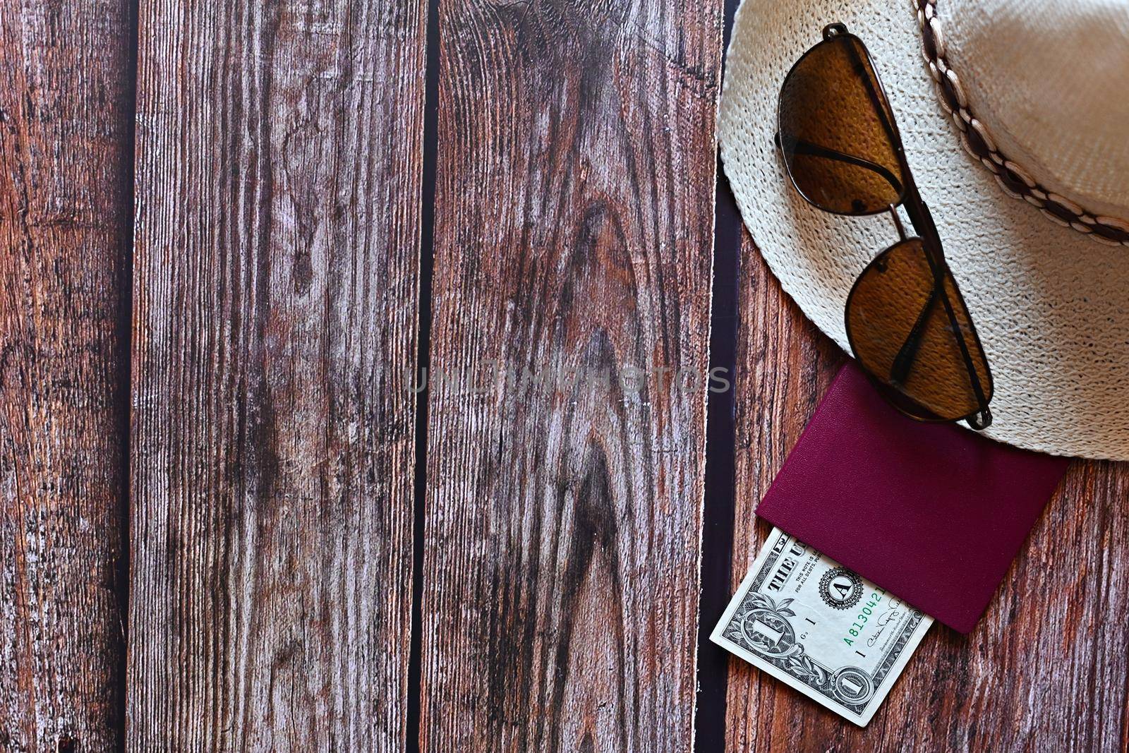 Items for summer vacation: a camera, passport,smartphone, money, hat, sunglasses. Wooden background, top view with Copy space. Beautiful summer concept for travel and summer vacation. by Montypeter