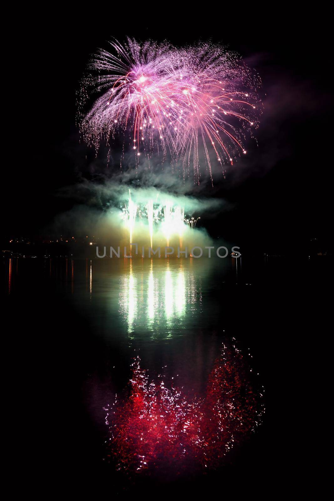 Beautiful colorful fireworks on the water surface with a clean black background. Fun festival and international contest of Firefighters from all over the world Ignis Brunensis 2017. Brno Dam - Czech Republic.