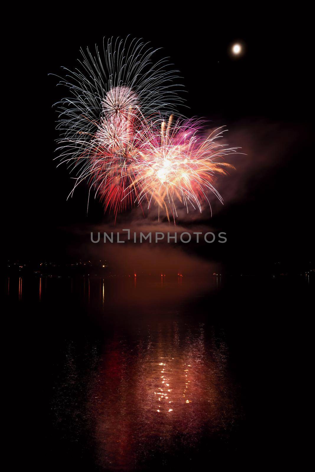 Beautiful colorful fireworks on the water surface with a clean black background. Fun festival and international contest of Firefighters from all over the world Ignis Brunensis 2017. Brno Dam - Czech Republic.