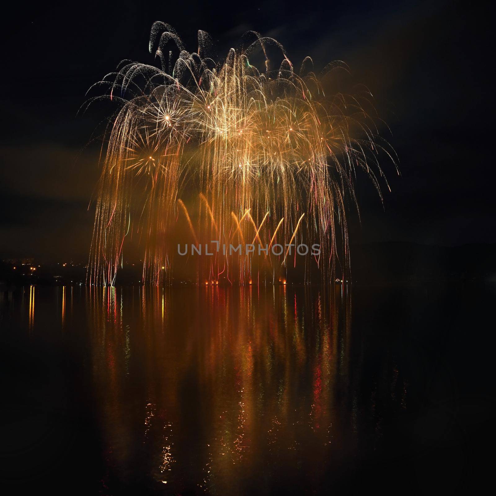 Beautiful colorful fireworks on the water surface with a clean black background. Fun festival and international contest of Firefighters from all over the world Ignis Brunensis 2017. Brno Dam - Czech Republic. by Montypeter