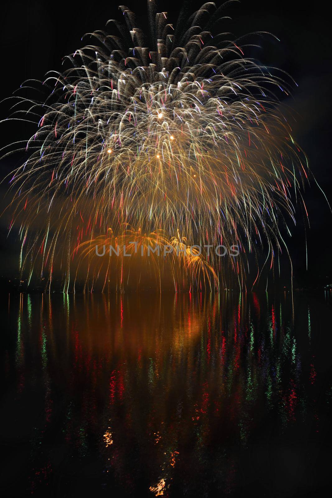 Beautiful colorful fireworks on the water surface with a clean black background. Fun festival and international contest of Firefighters from all over the world Ignis Brunensis 2017. Brno Dam - Czech Republic.