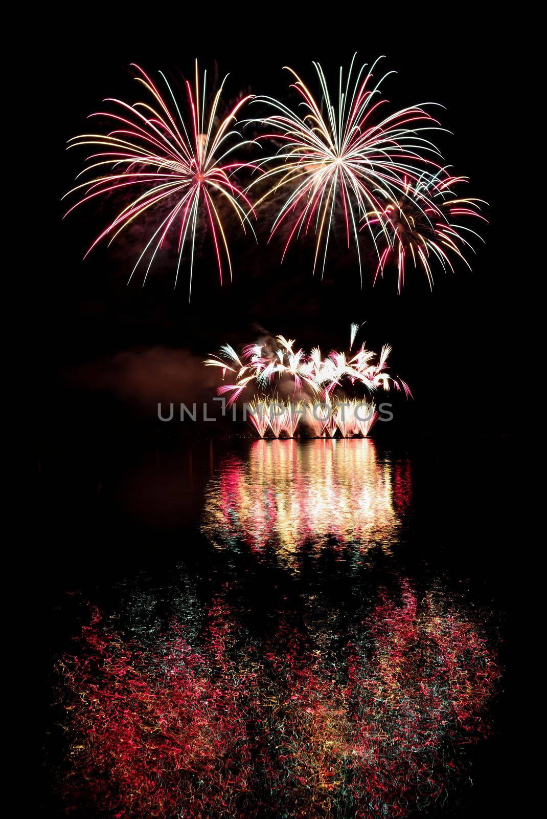 Firework. Beautiful colorful fireworks on the water surface with a clean black background. Fun festival and contest of Firefighters  Brno Dam - Czech Republic.