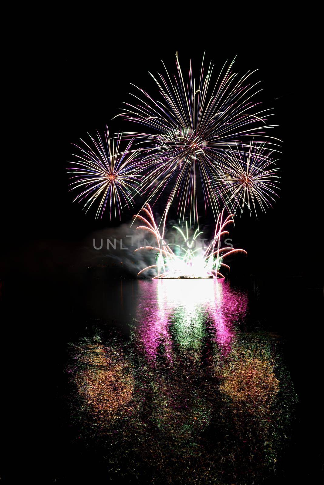 Firework. Beautiful colorful fireworks on the water surface with a clean black background. Fun festival and contest of Firefighters  Brno Dam - Czech Republic. by Montypeter