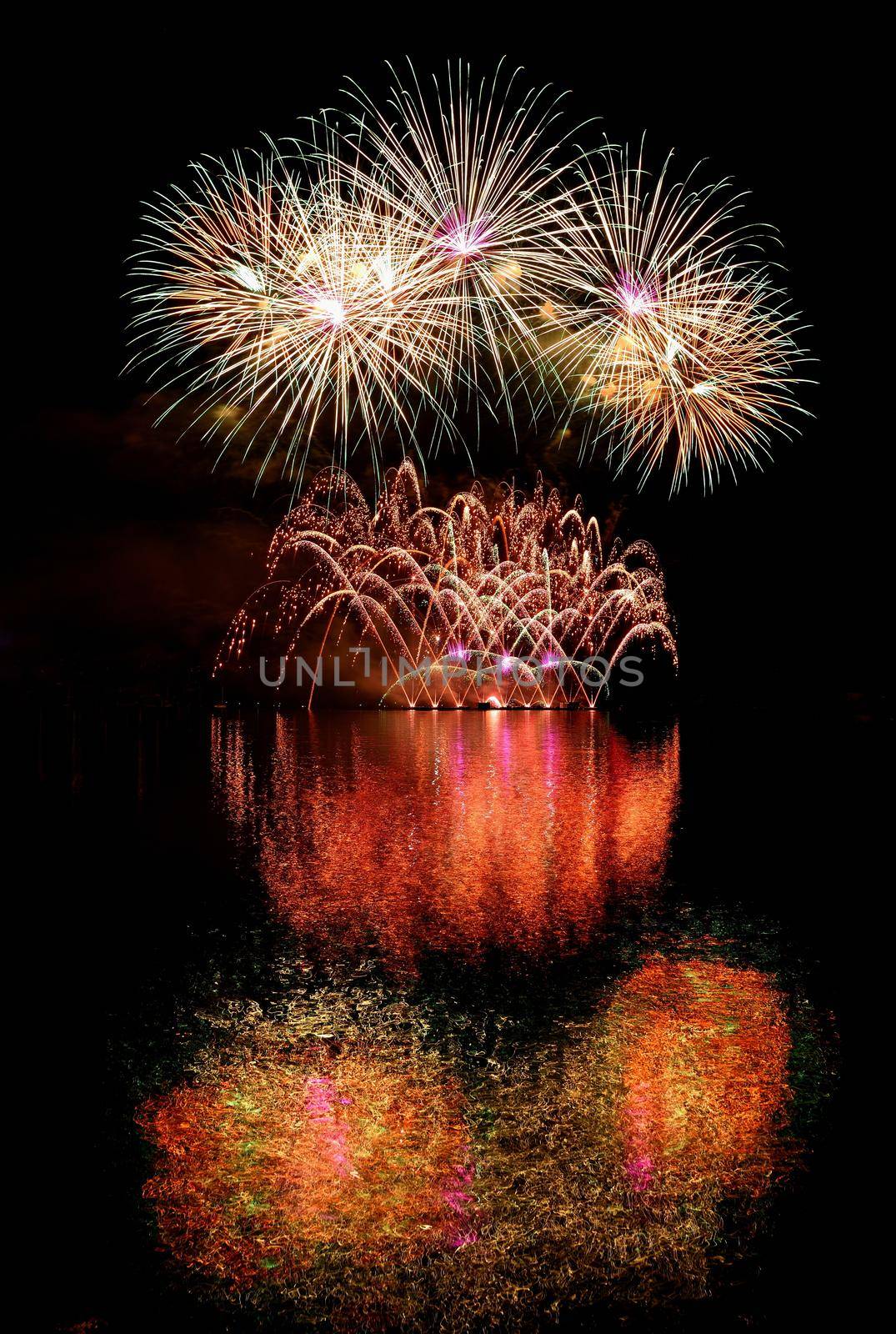 Firework. Beautiful colorful fireworks on the water surface with a clean black background. Fun festival and contest of Firefighters  Brno Dam - Czech Republic.