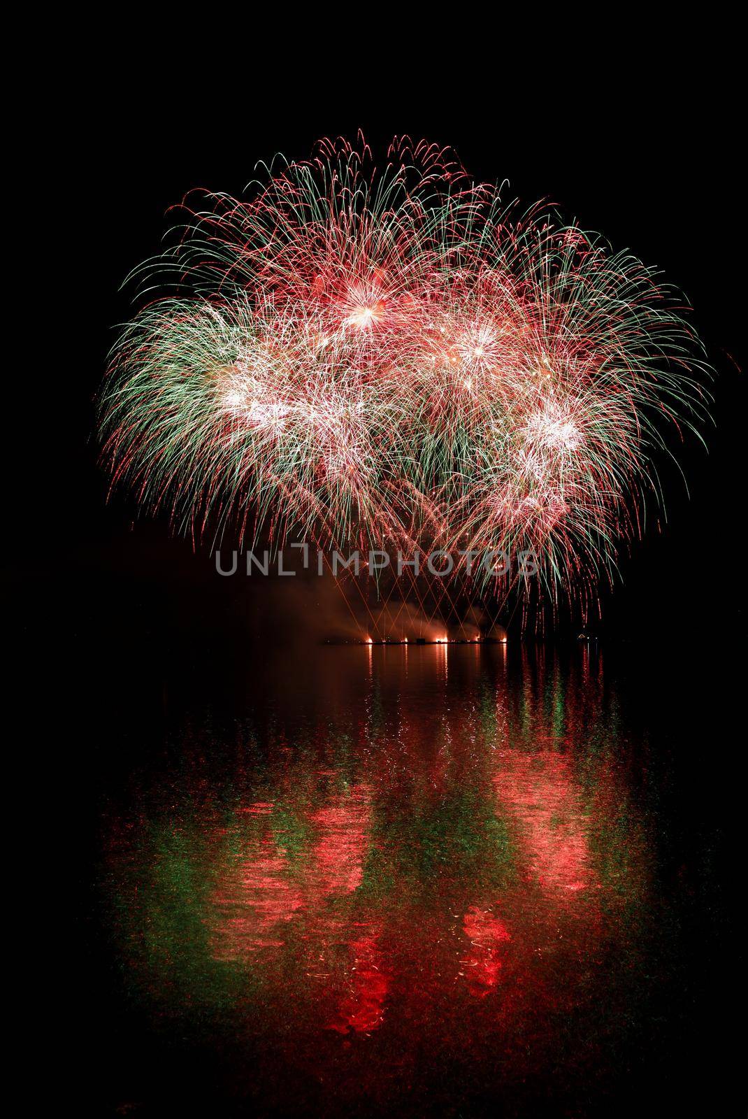 Firework. Beautiful colorful fireworks on the water surface with a clean black background. Fun festival and contest of Firefighters  Brno Dam - Czech Republic.