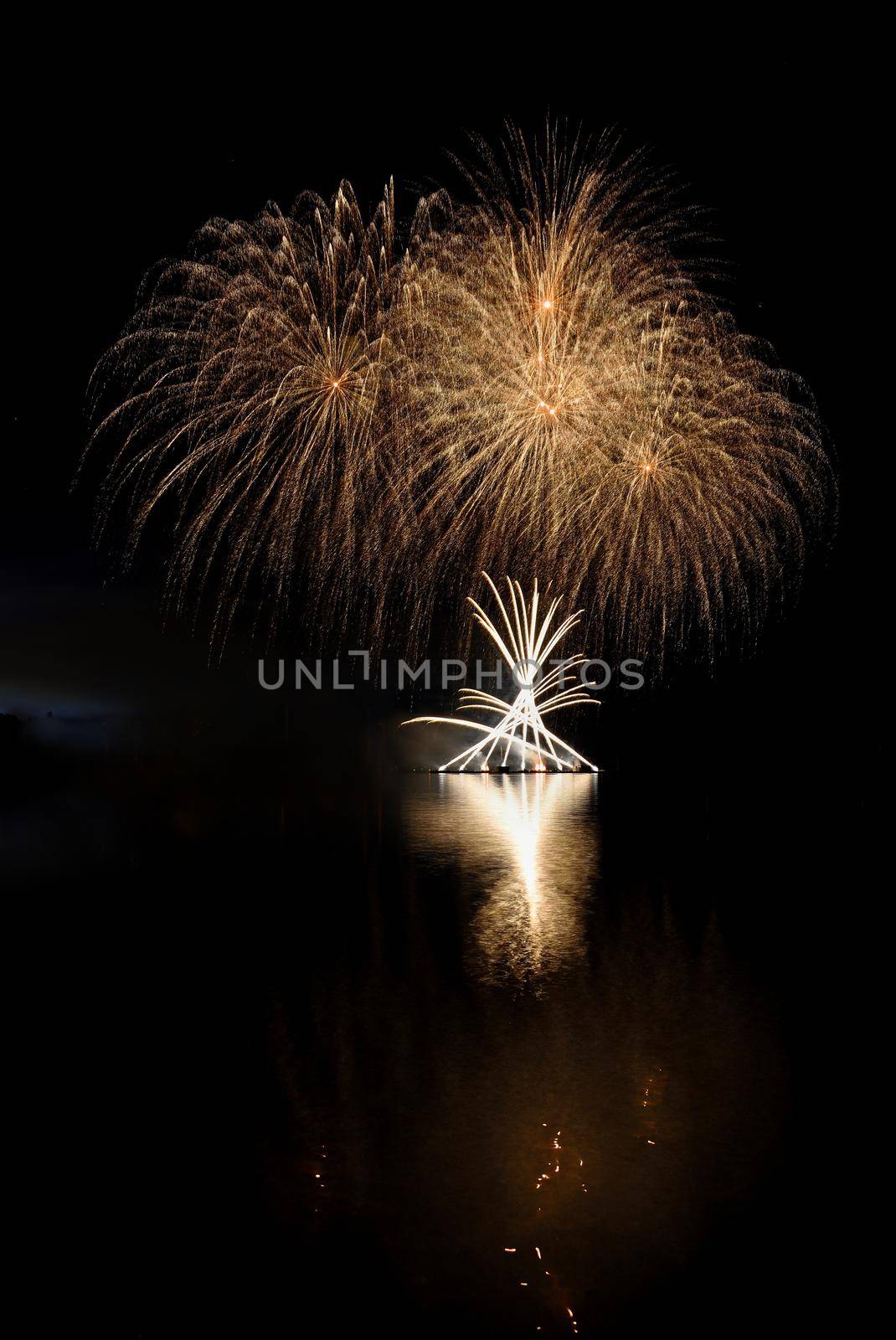 Firework. Beautiful colorful fireworks on the water surface with a clean black background. Fun festival and contest of Firefighters  Brno Dam - Czech Republic.