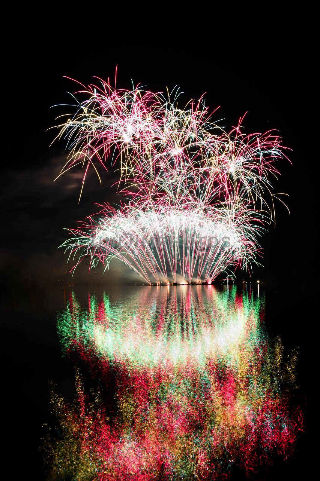 Firework. Beautiful colorful fireworks on the water surface with a clean black background. Fun festival and contest of Firefighters  Brno Dam - Czech Republic.