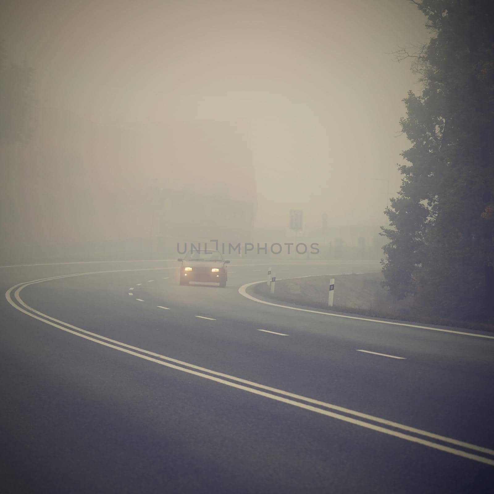 Bad weather driving - foggy hazy country road. Motorway - road traffic. Winter time.