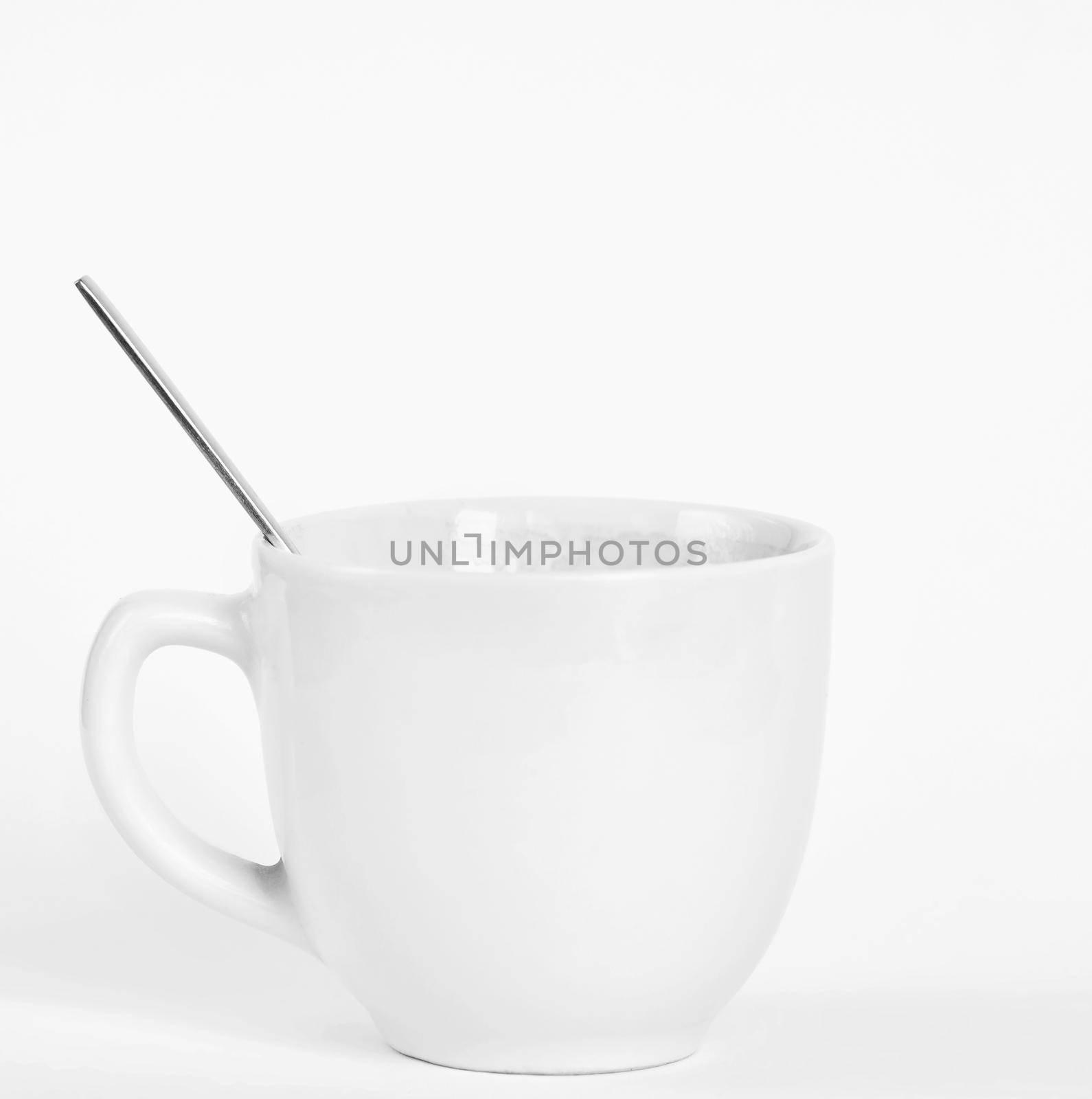 A small white cup of coffee with a spoon. Isolated on a clean white background. by Montypeter