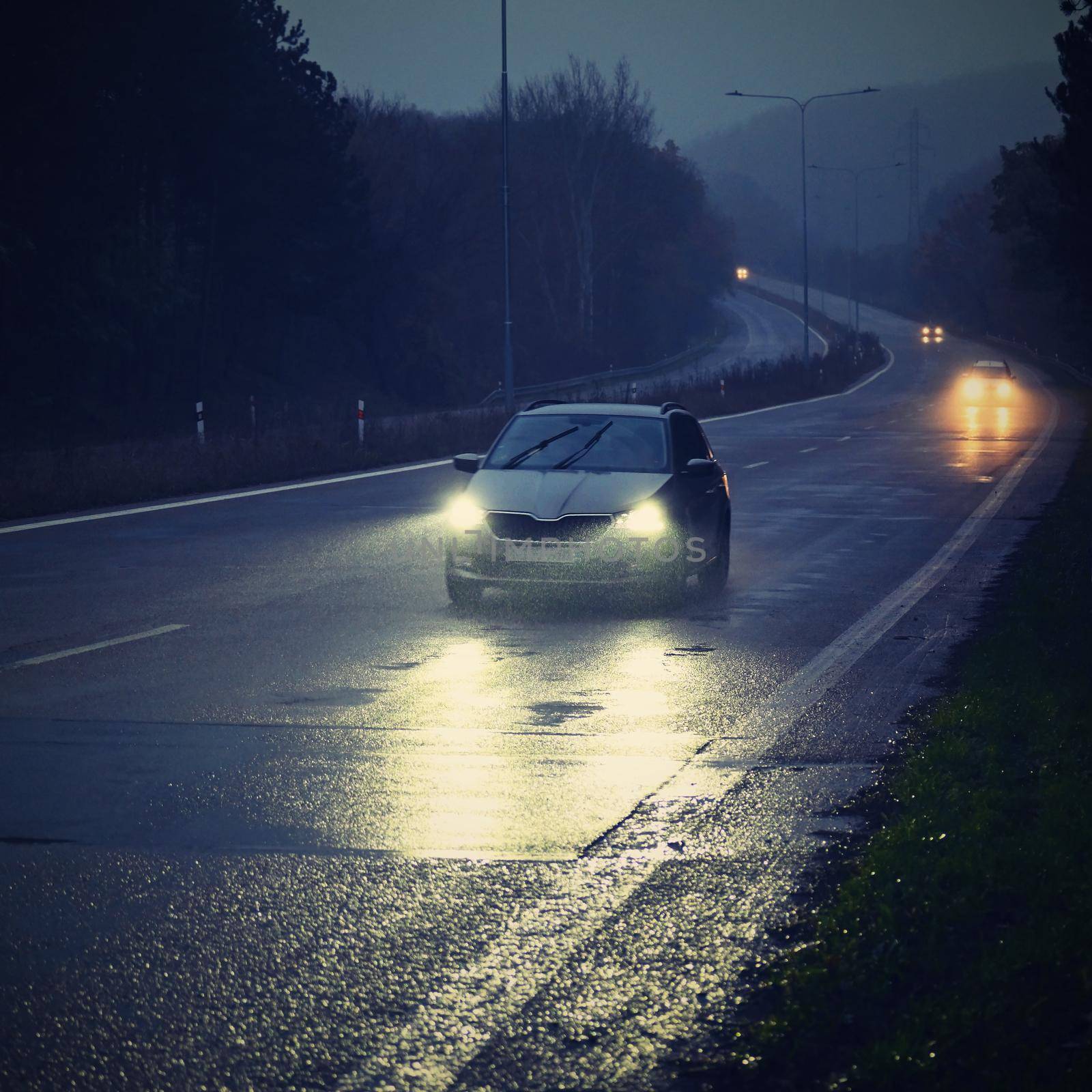 Car on the road in the fog. Autumn landscape - dangerous road traffic in winter season. by Montypeter