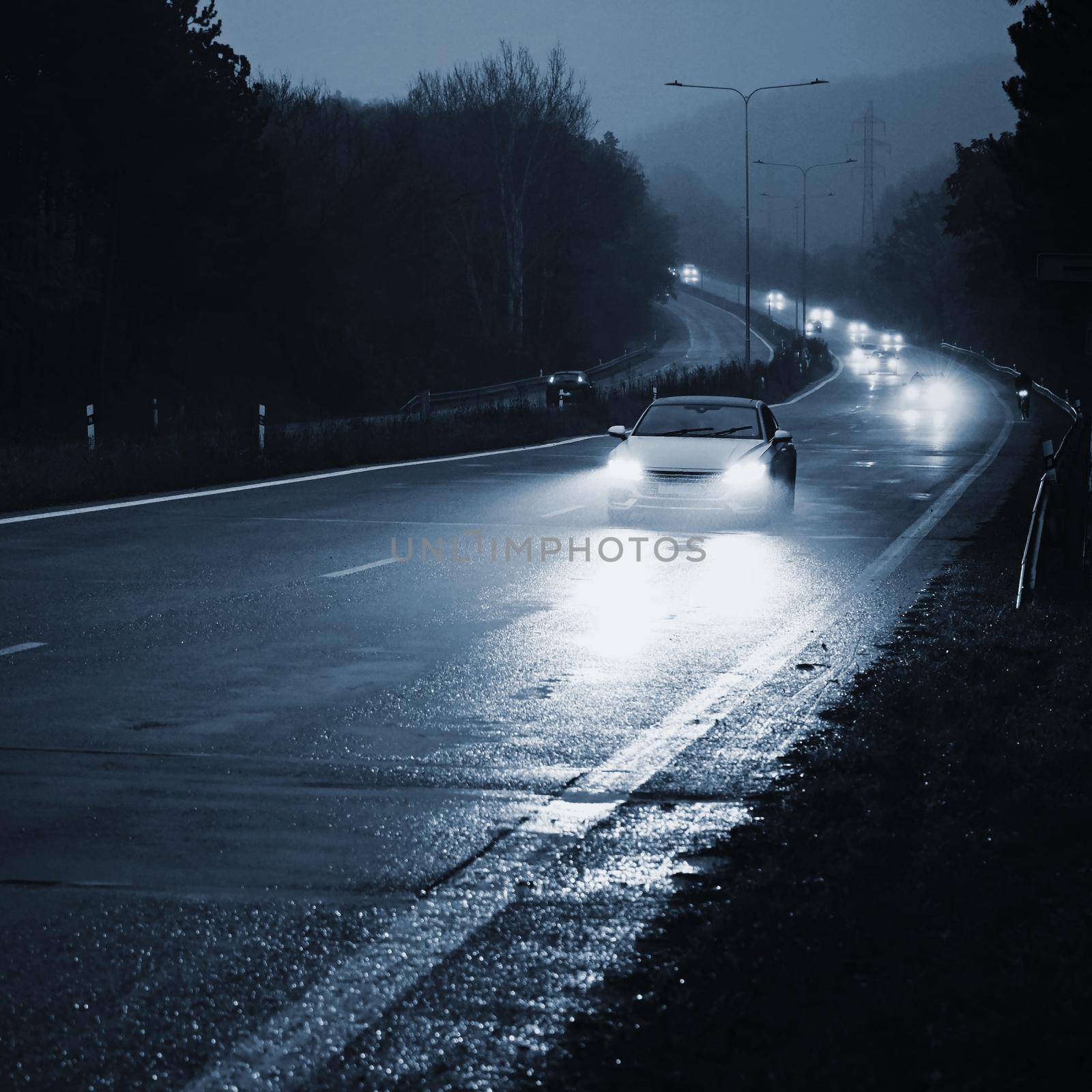 Car on the road in the fog. Autumn landscape - dangerous road traffic in winter season. by Montypeter