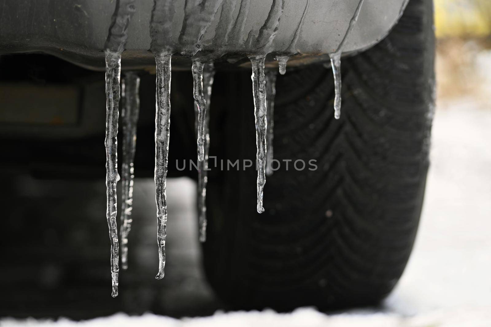 Beautiful icicles on the car. Concept for winter and dangerous winter traffic of cars on the road.