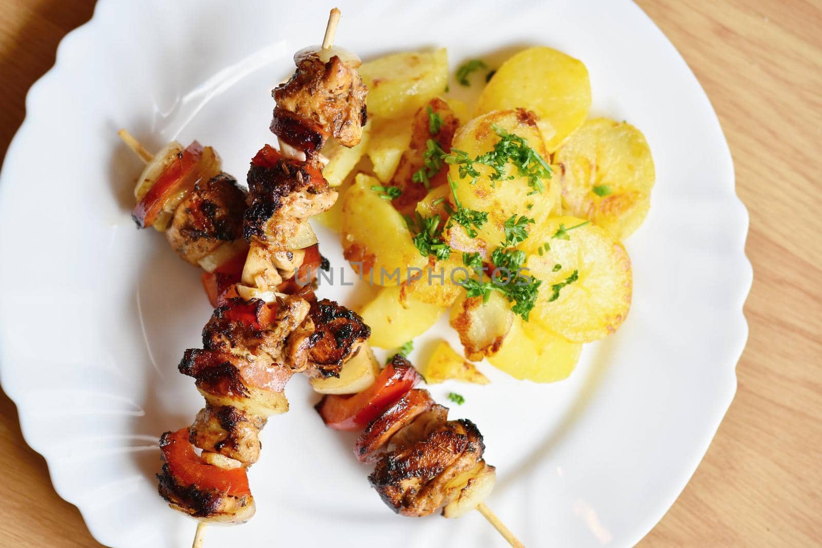 Chicken skewer with potatoes and parsley. Excellent meat with vegetables.