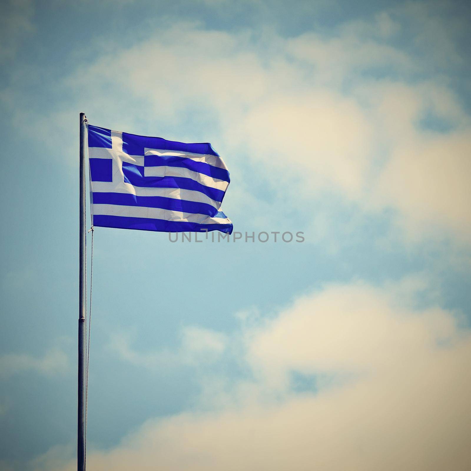 Flag of Greece Flying in Wind and Blue Sky. Summer background for travel and holidays. Greece Crete.