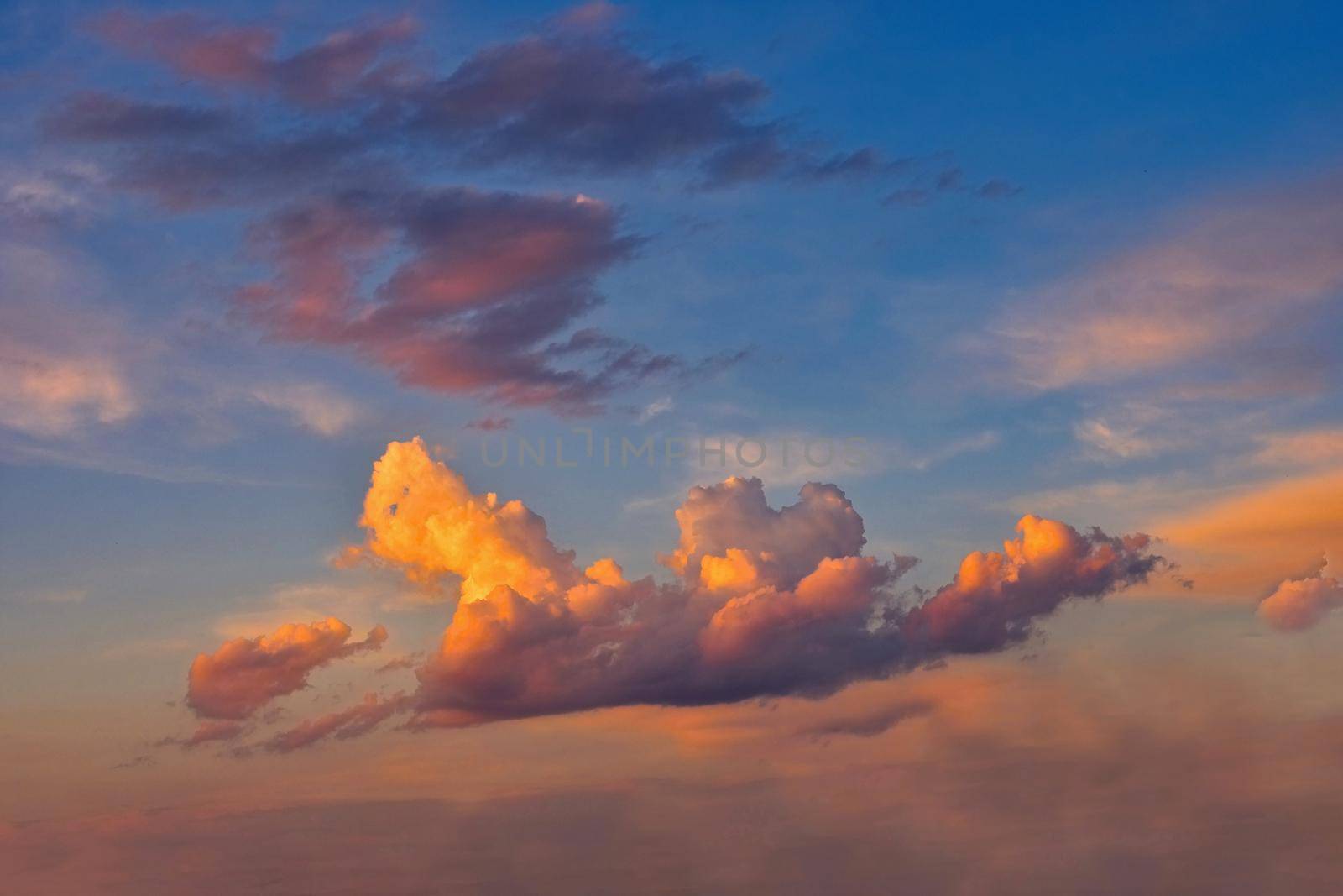 Beautiful colorful clouds on blue sky at sunset. Romantic background concept.