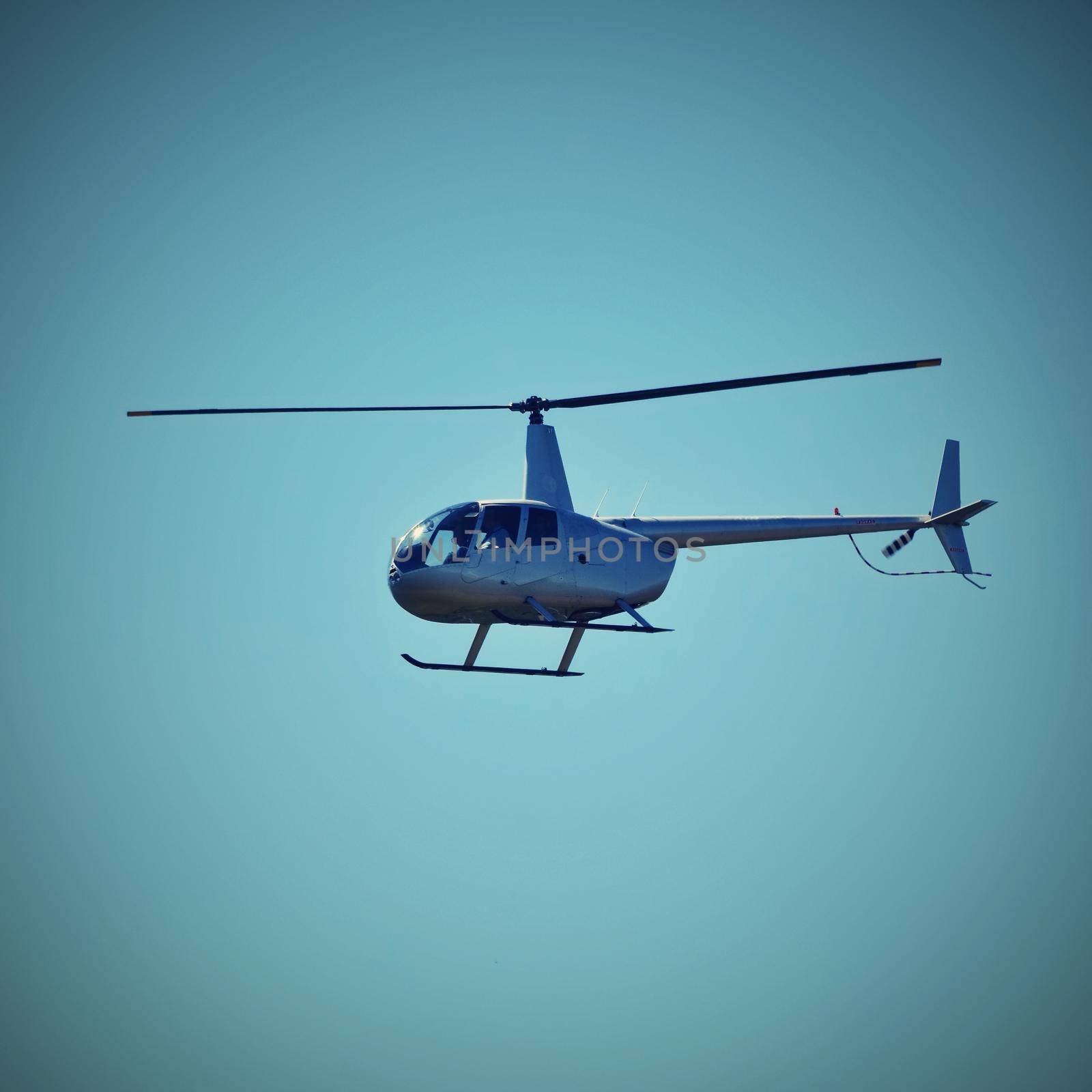 Helicopter flying against the blue sky by Montypeter