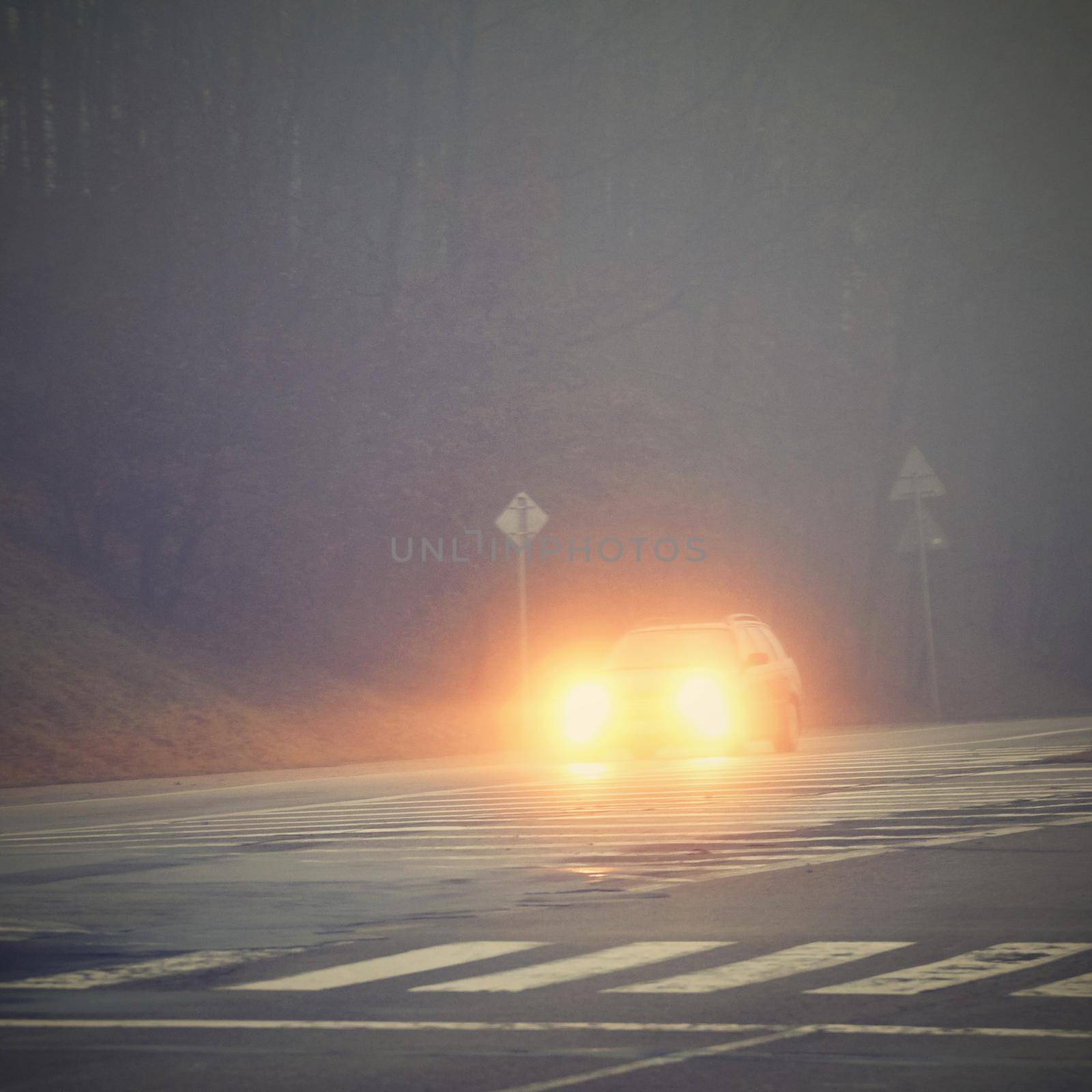 Cars in the fog. Bad winter weather and dangerous automobile traffic on the road. Light vehicles in fog.