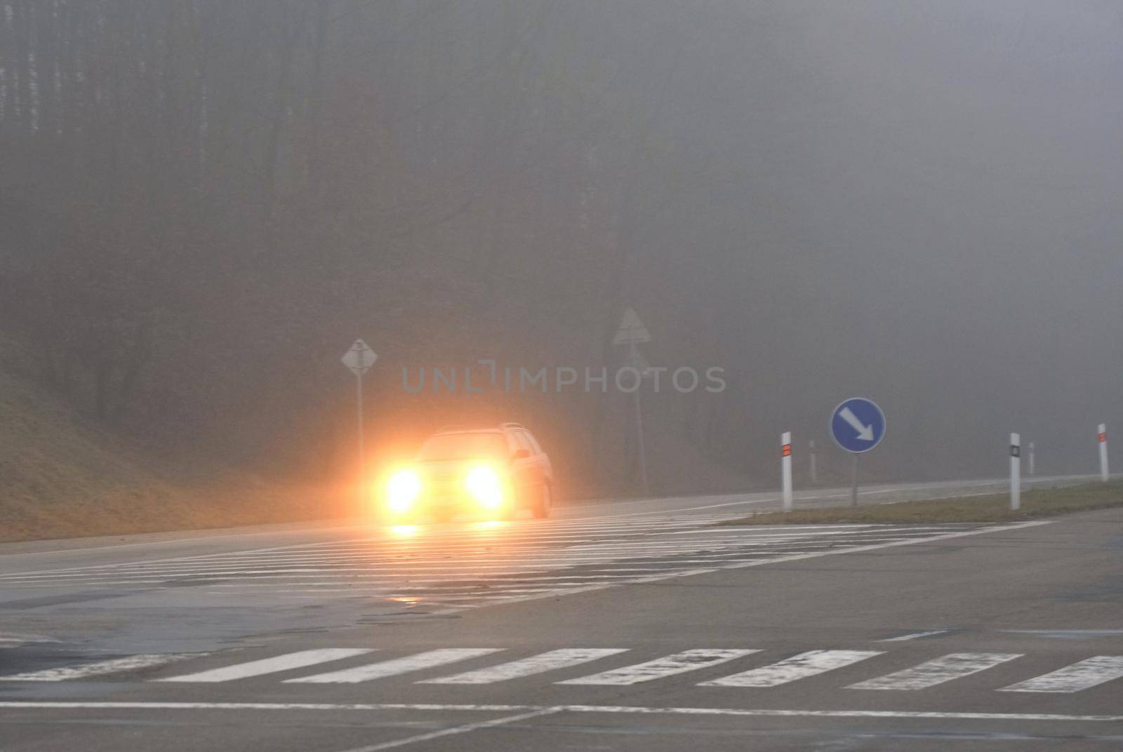 Cars in the fog. Bad winter weather and dangerous automobile traffic on the road. Light vehicles in fog.