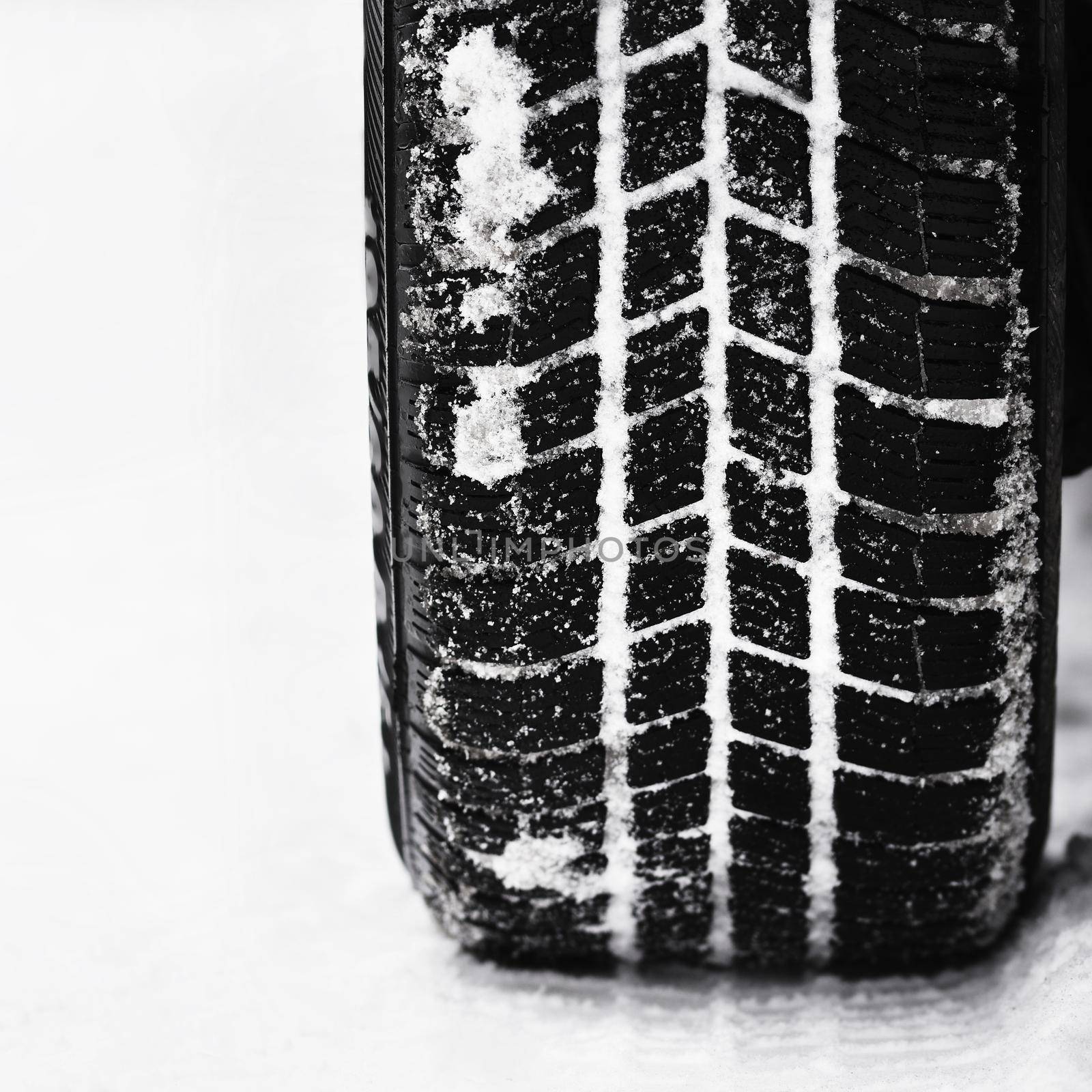 Car tires on winter road. Beautiful winter seasonal  background.