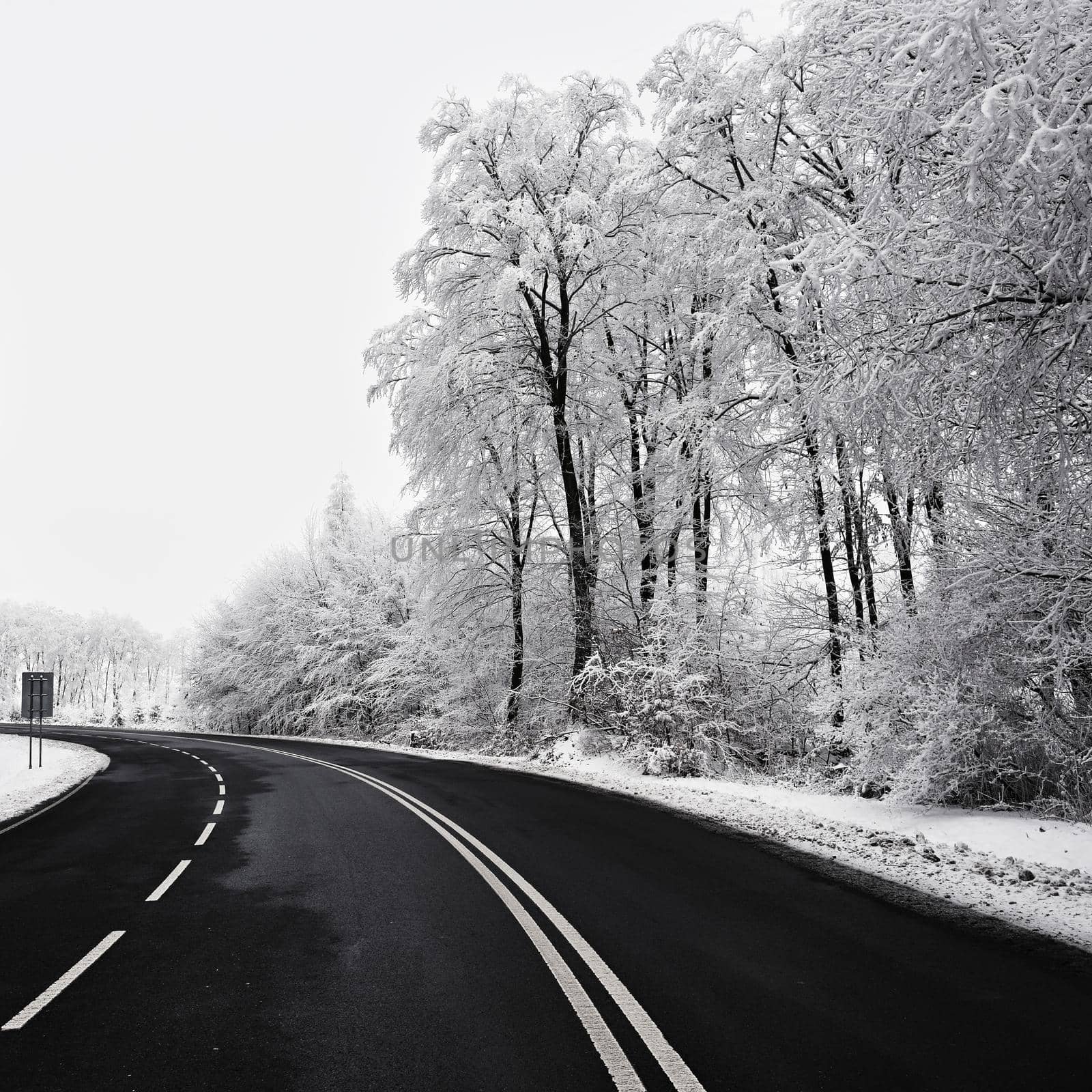 Empty road with snow covered landscape. Beautiful winter seasonal background for transport and cars.