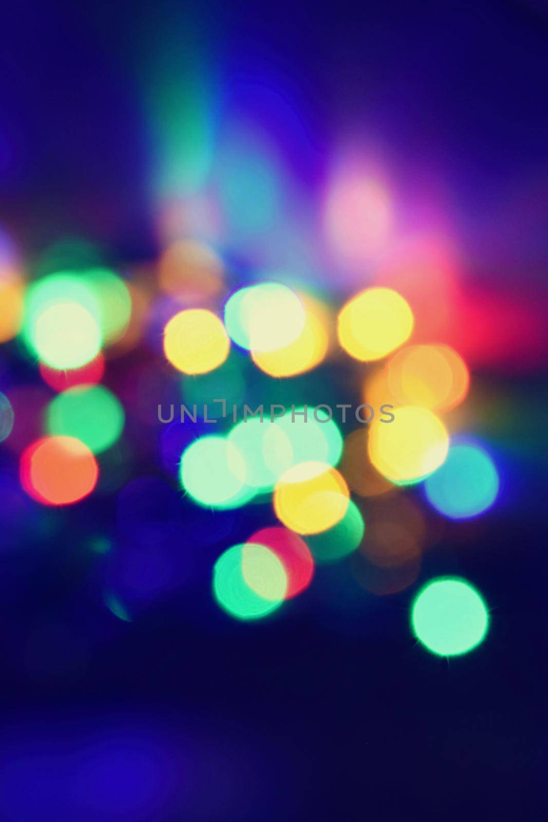 Christmas blurred lights on black background with copy space. Abstract colorful reflections of bulbs on a Christmas tree. by Montypeter