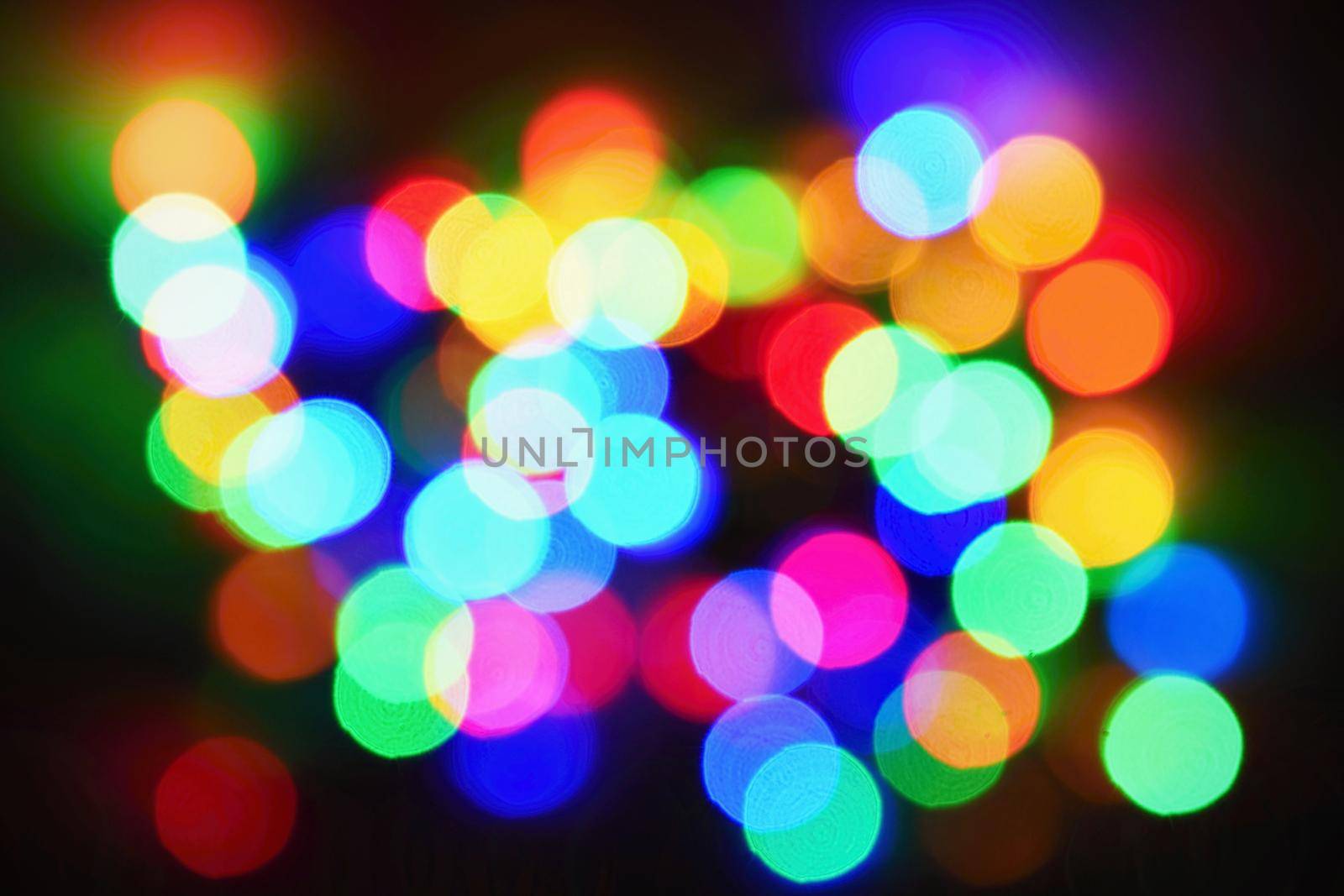 Christmas lights on black background with copy space. Colored reflecting surface.