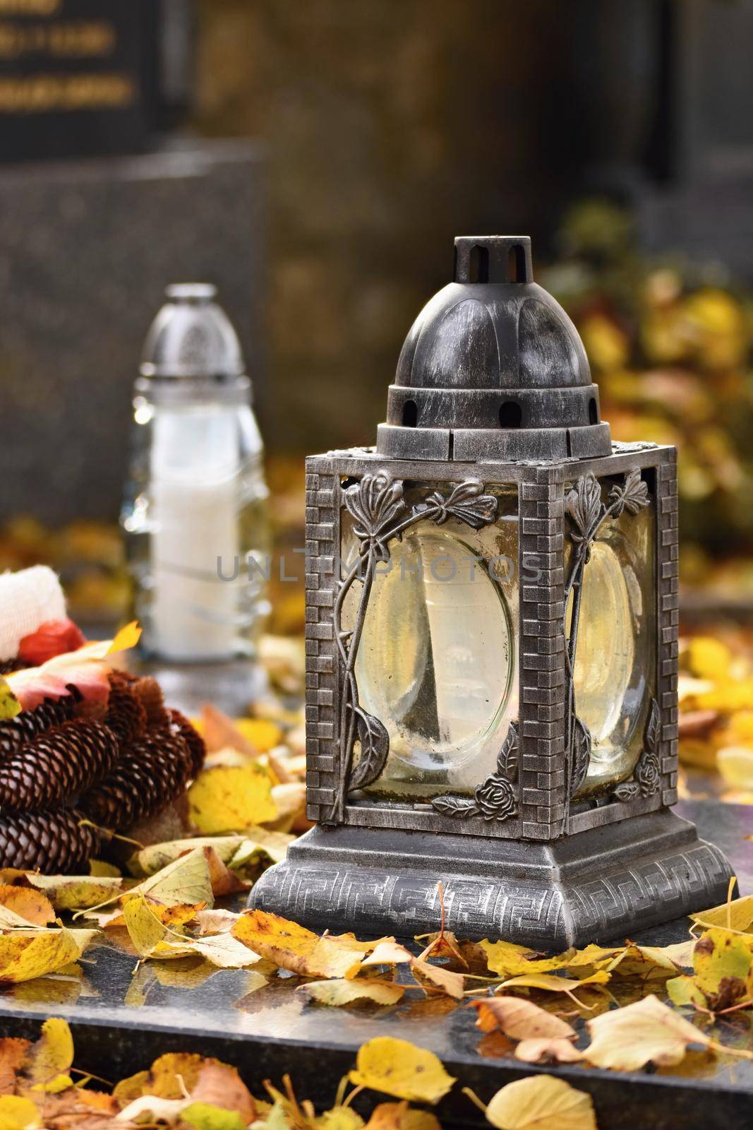 Beautiful autumn concept to the cemetery and Halloween. Candle in a lantern on the grave. Background for Halloween.