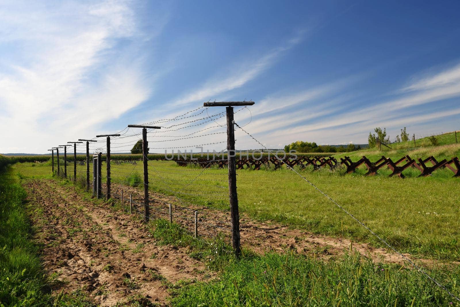 Watchtower and line of defense, old state border of the Iron Curtain - barbed fence. Memorial military area - Satov Czech Republic. by Montypeter