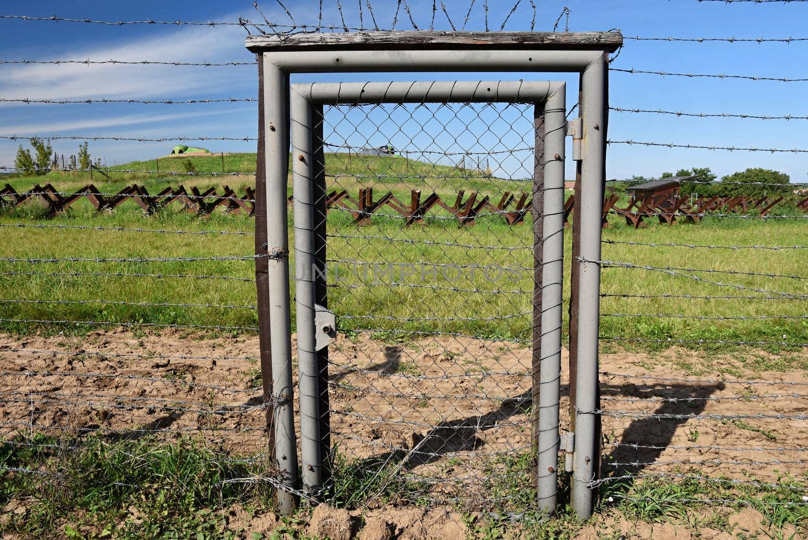 Watchtower and line of defense, old state border of the Iron Curtain - barbed fence. Memorial military area - Satov Czech Republic. by Montypeter