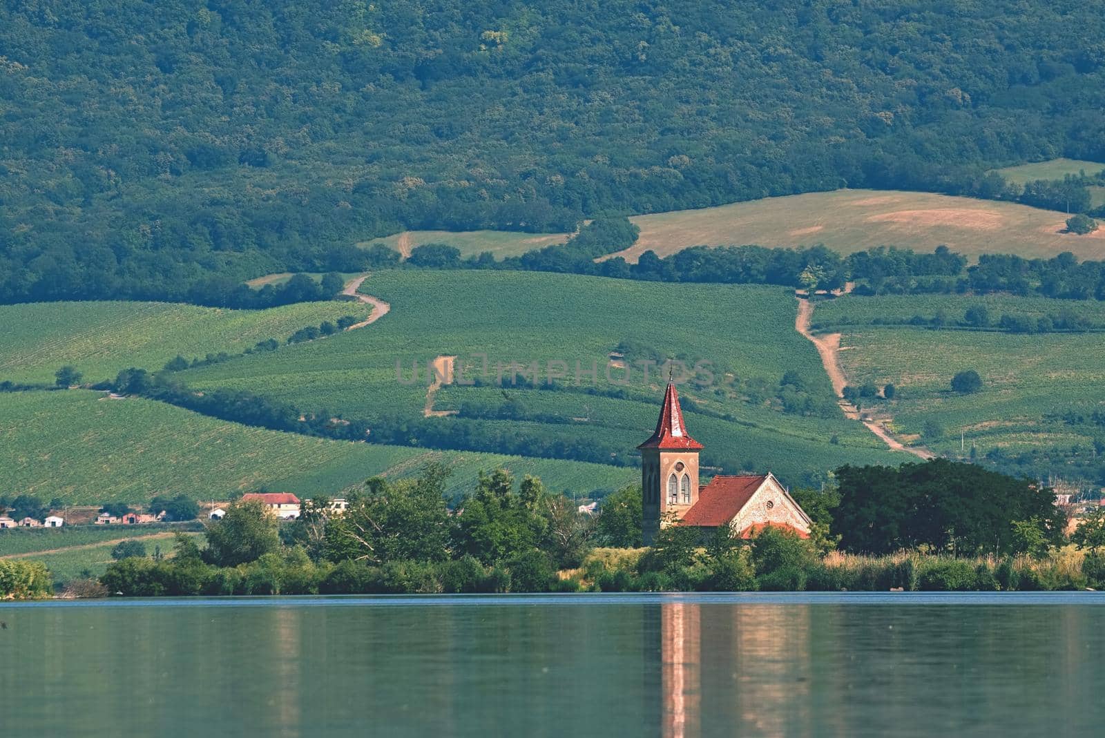 The island with the old church in the middle of the lake. Landscape under Palava. Czech Republic - South Moravian Region wine region. Water tank - New Mills - Pasohlavky. by Montypeter