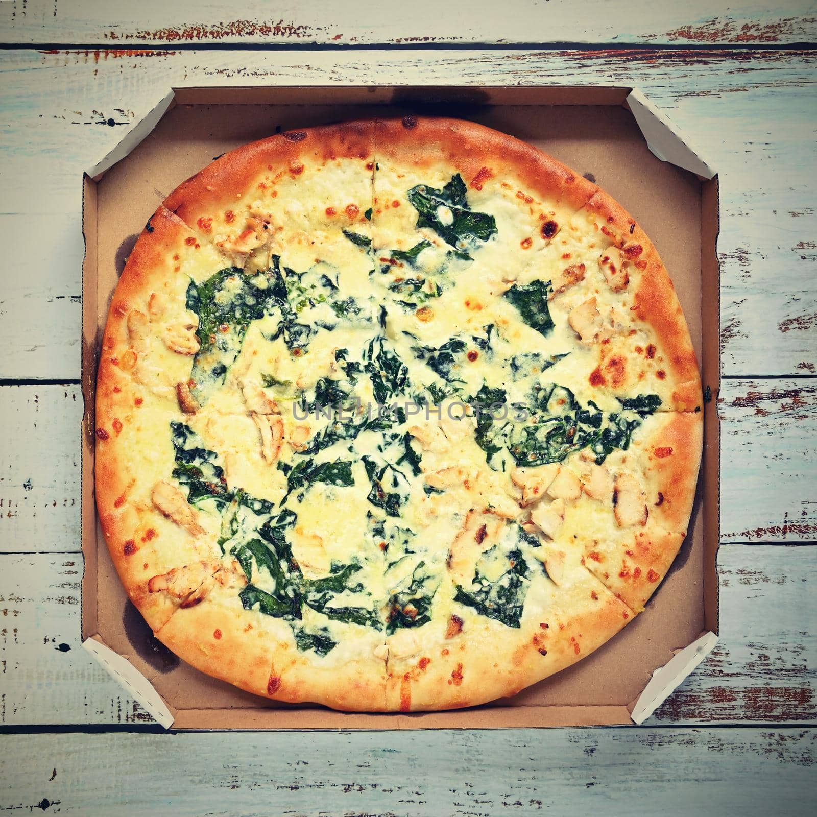 Delicious fresh pizza in a box on a wooden background. Concept for food - fast food - home delivery.