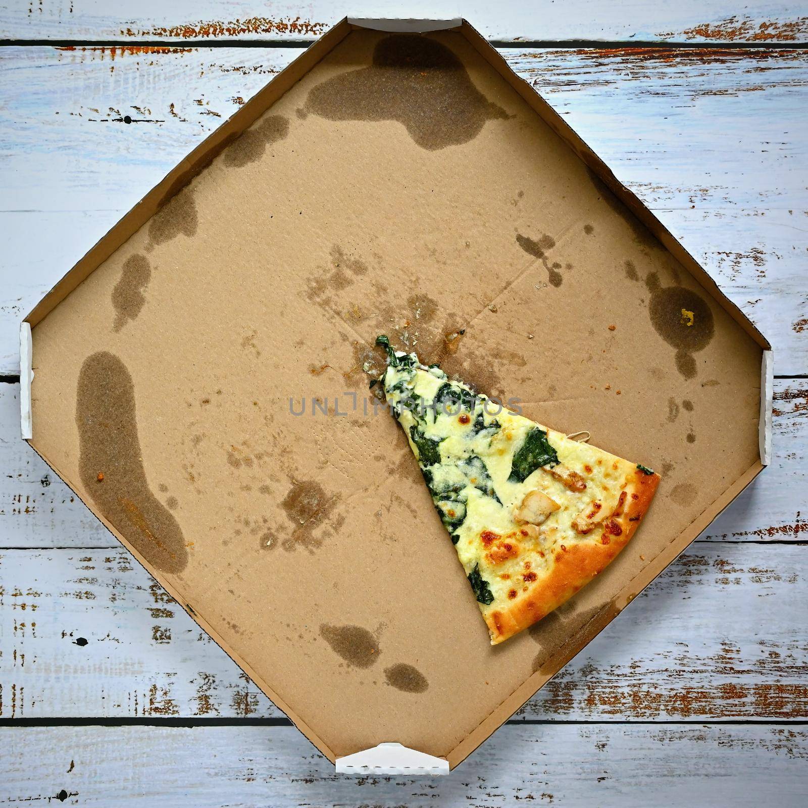 Delicious fresh pizza in a box on a wooden background. Concept for food - fast food - home delivery. by Montypeter