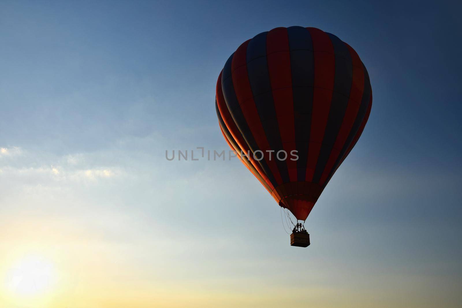 Colorful hot air balloon is flying at sunset. Natural colorful background with sky. by Montypeter