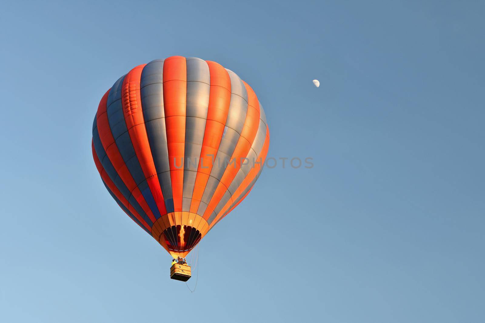 Colorful hot air balloon is flying at sunset. Natural colorful background with sky. by Montypeter