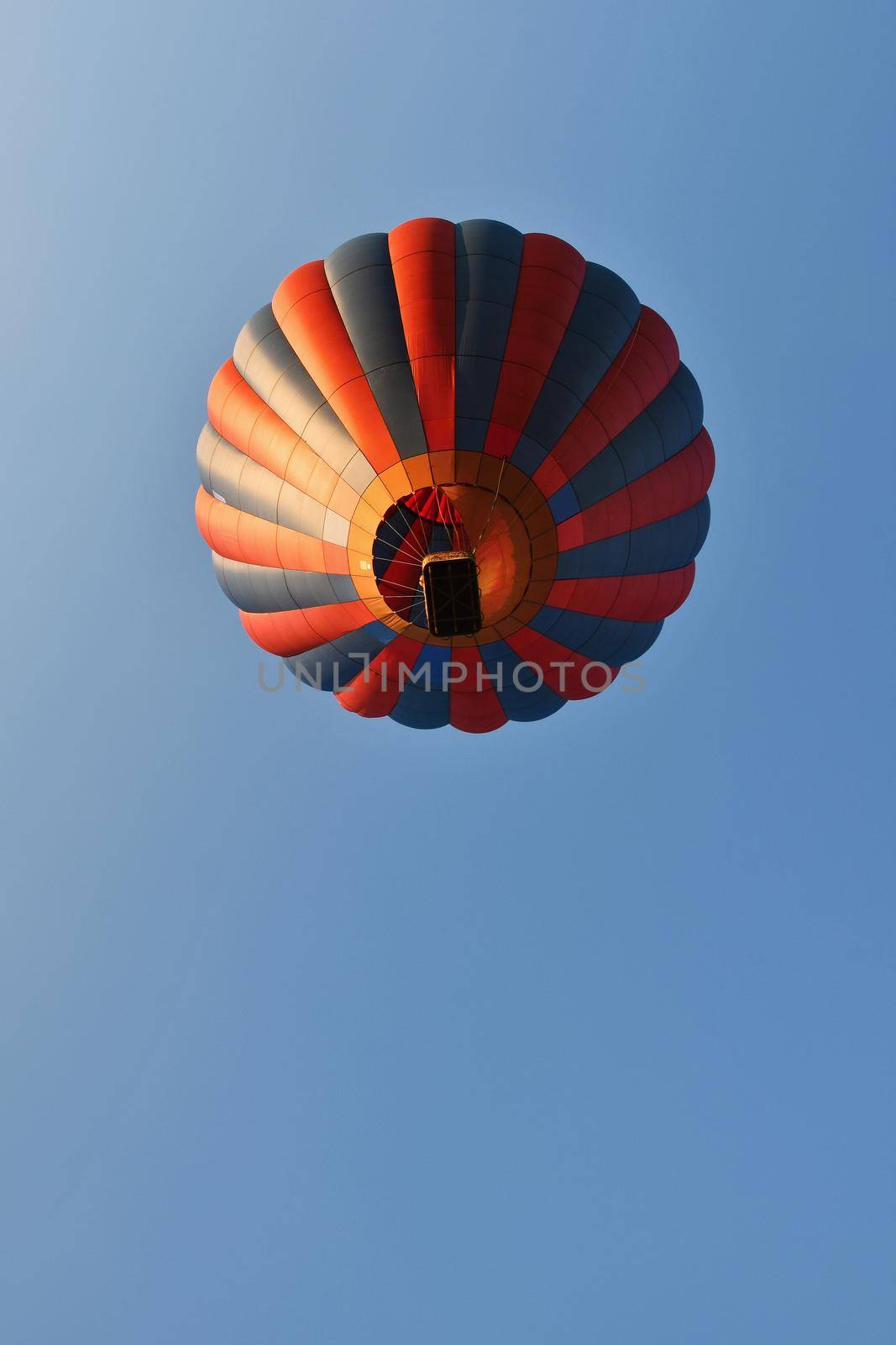 Colorful hot air balloon is flying at sunset. Natural colorful background with sky. by Montypeter