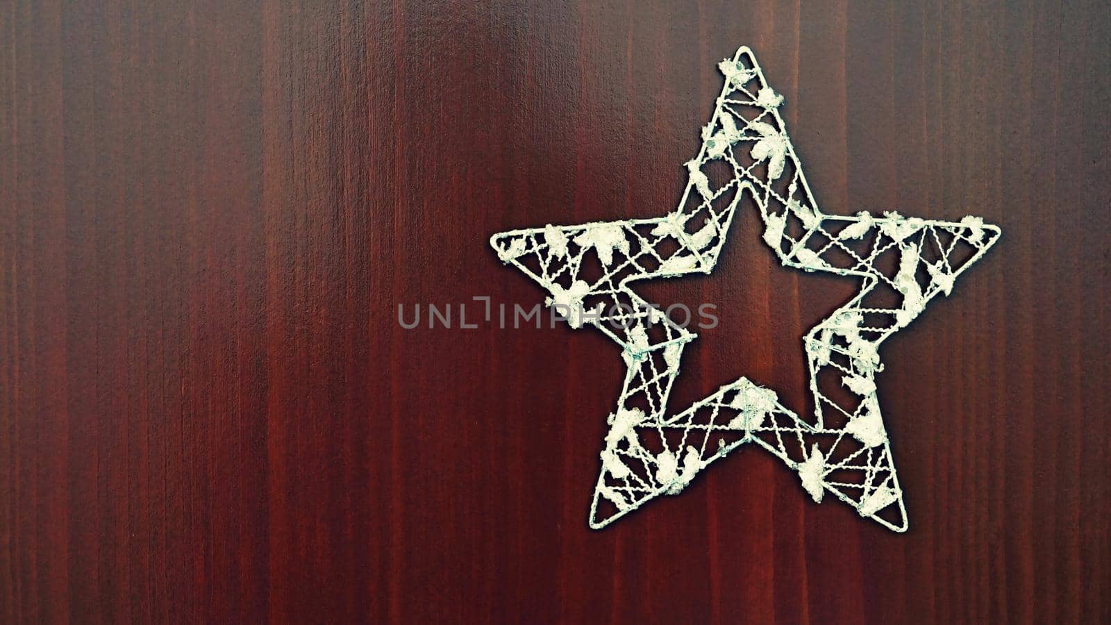 Christmas star ornament on a wooden background. Beautiful concept for Christmas time and winter.