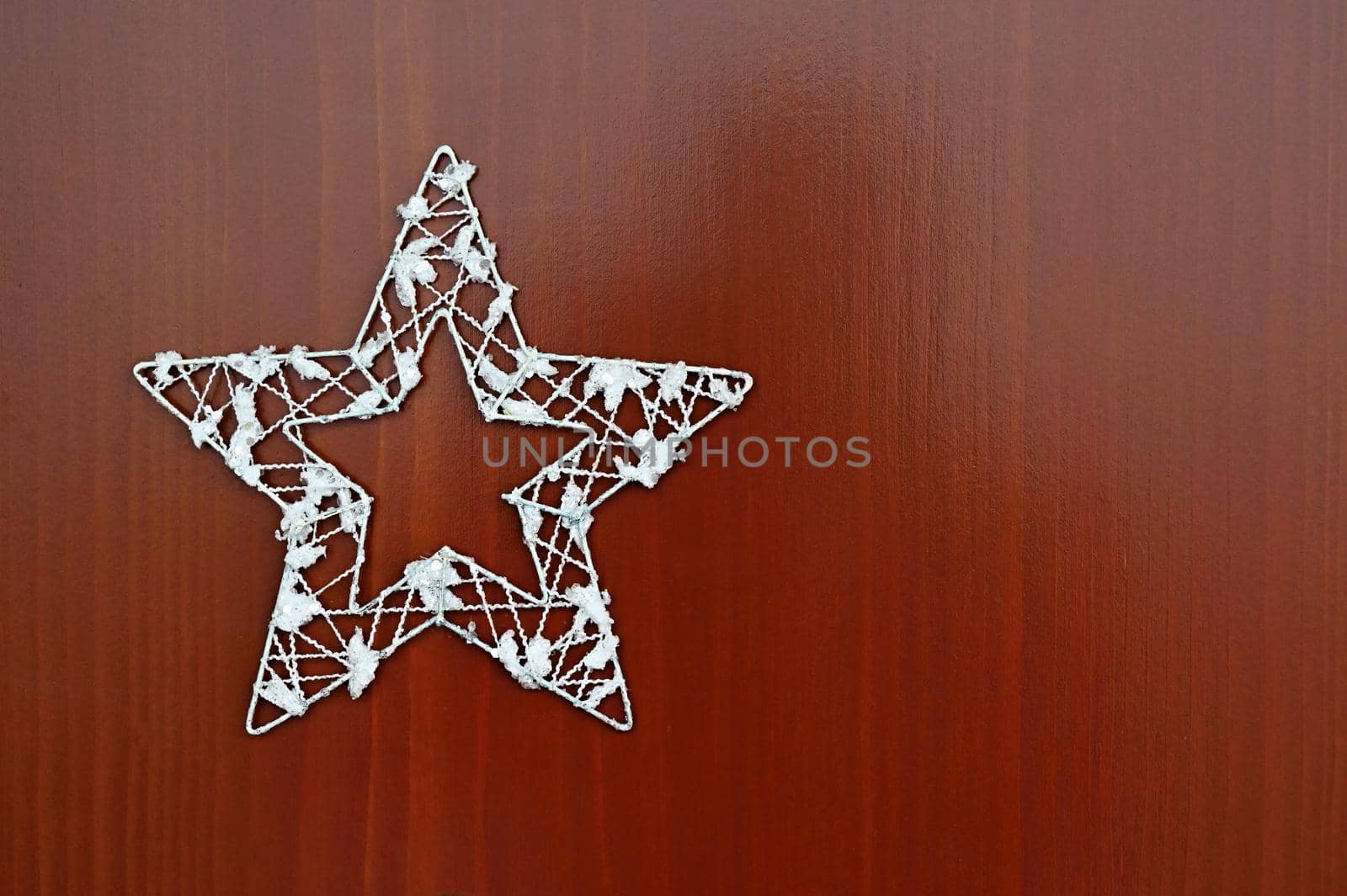 Christmas star ornament on a wooden background. Beautiful concept for Christmas time and winter.