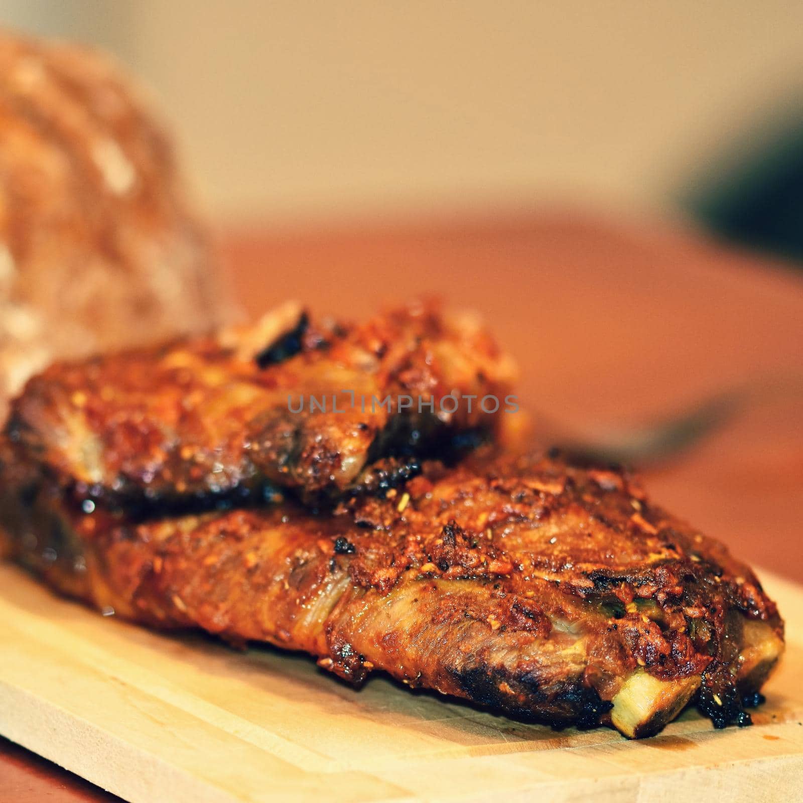 Roasted pork ribs. On wooden background bread.