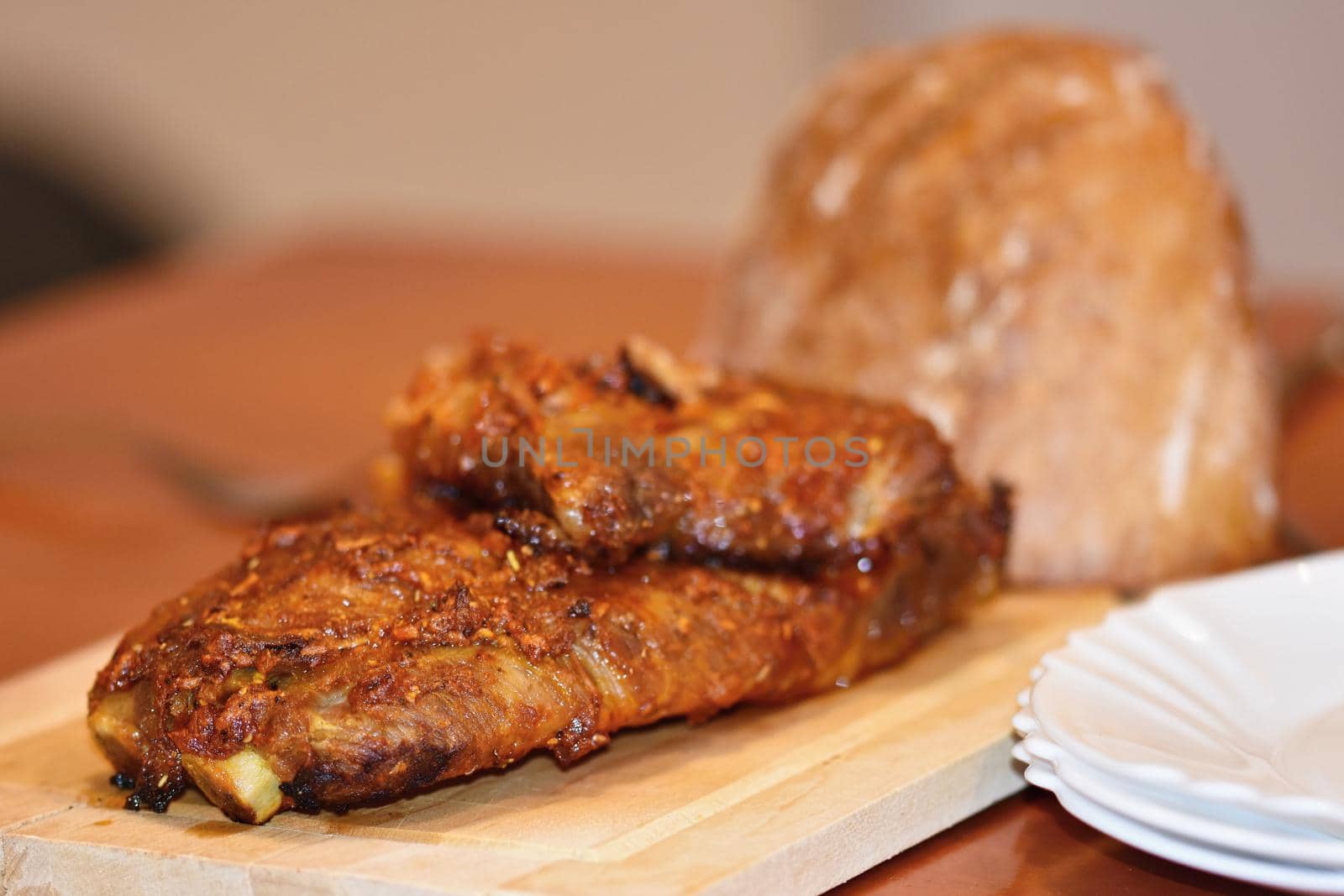 Roasted pork ribs. On wooden background and bread. by Montypeter