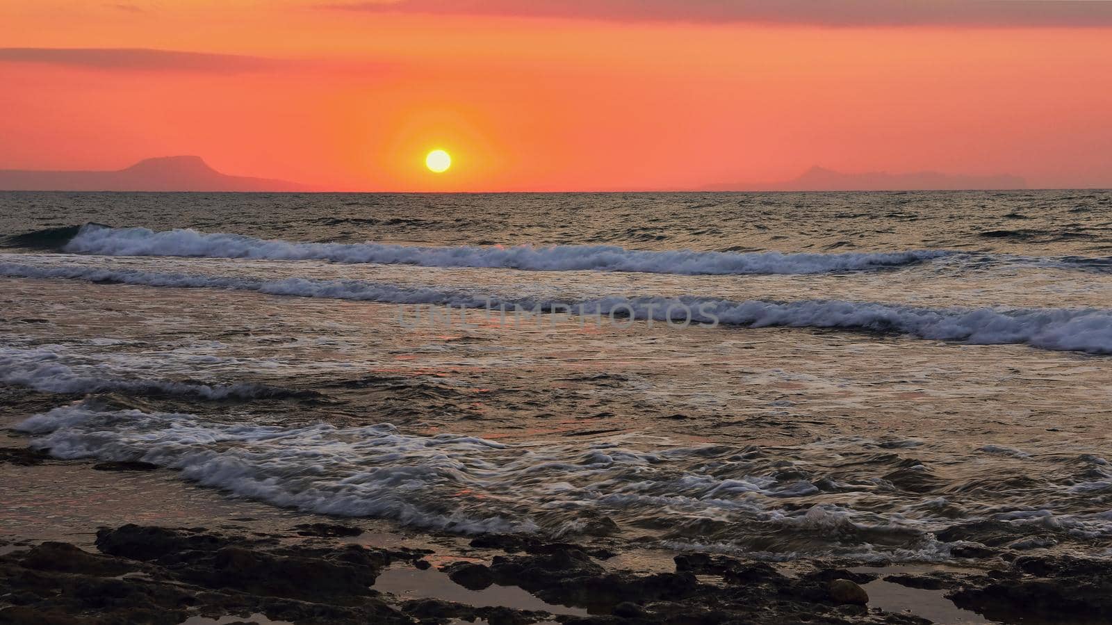 Beautiful sunset at the beach with the sea in the background. Landscape for summer holidays. by Montypeter